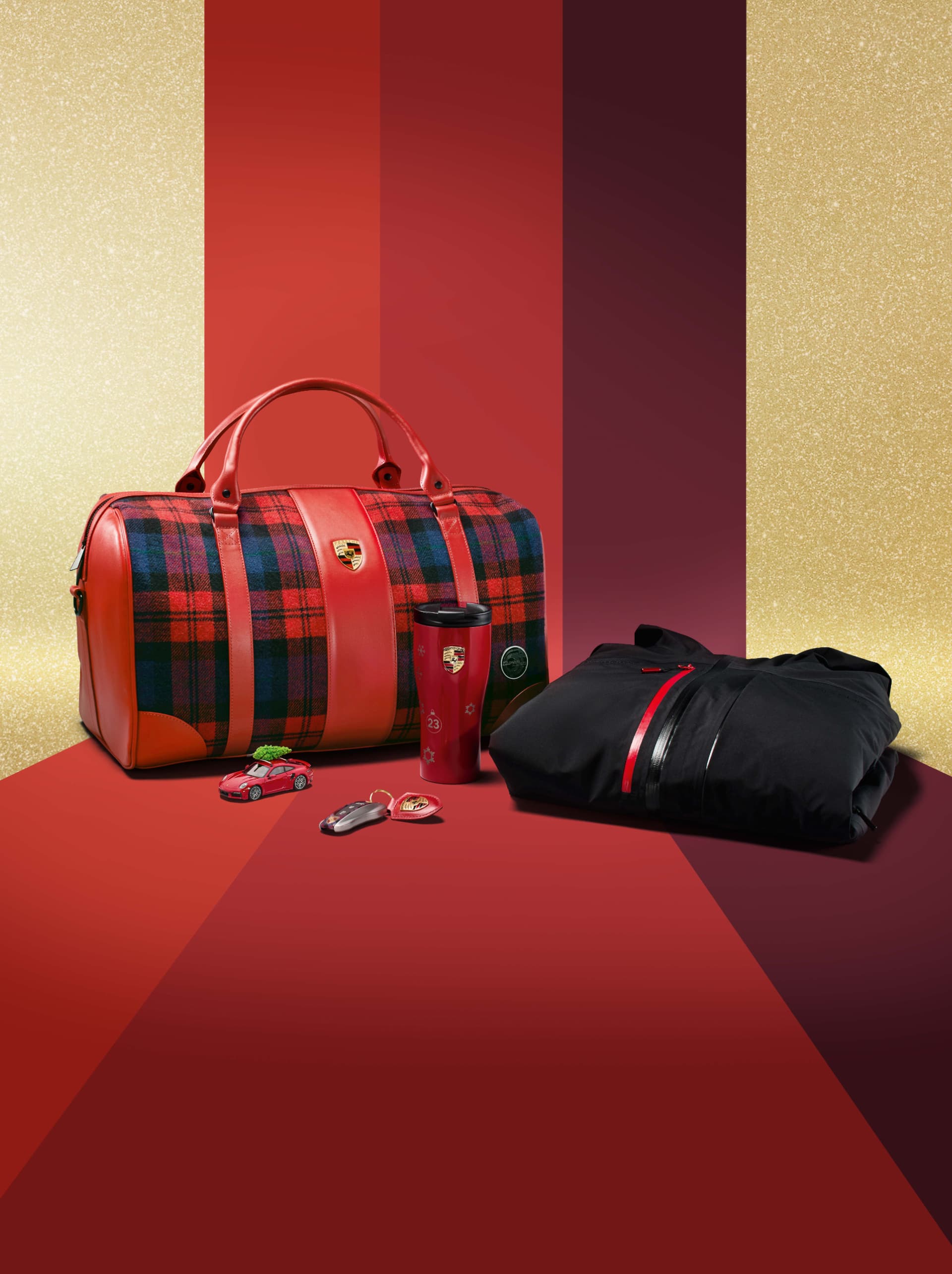 Red plaid bag, black jacket, red tumbler, toy car, and keychain on a red and gold striped background