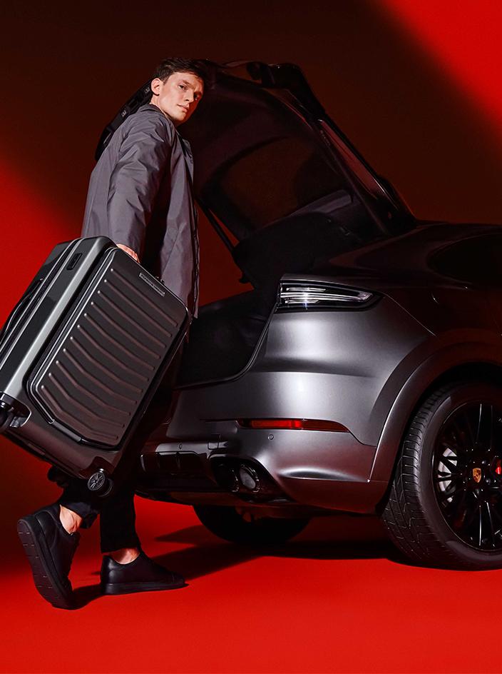 A woman standing next to three red hardcase trolley suitcases