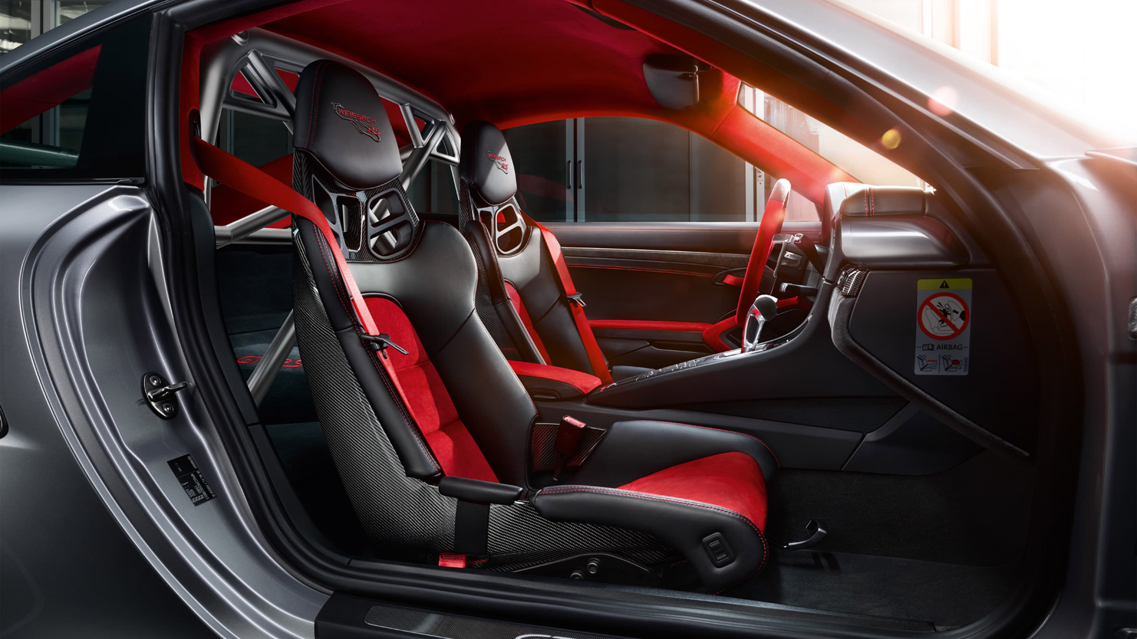 Zu sehen sind rot bis schwarze Sitze im Innenraum eines Porsche GT2 RS.
