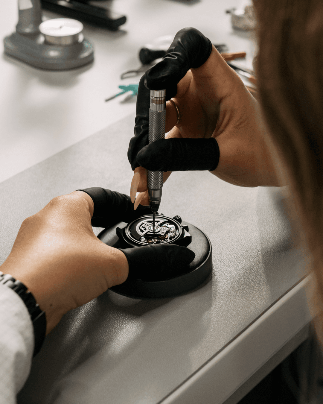 A watchmaker assembling a Porsche Design chronograph