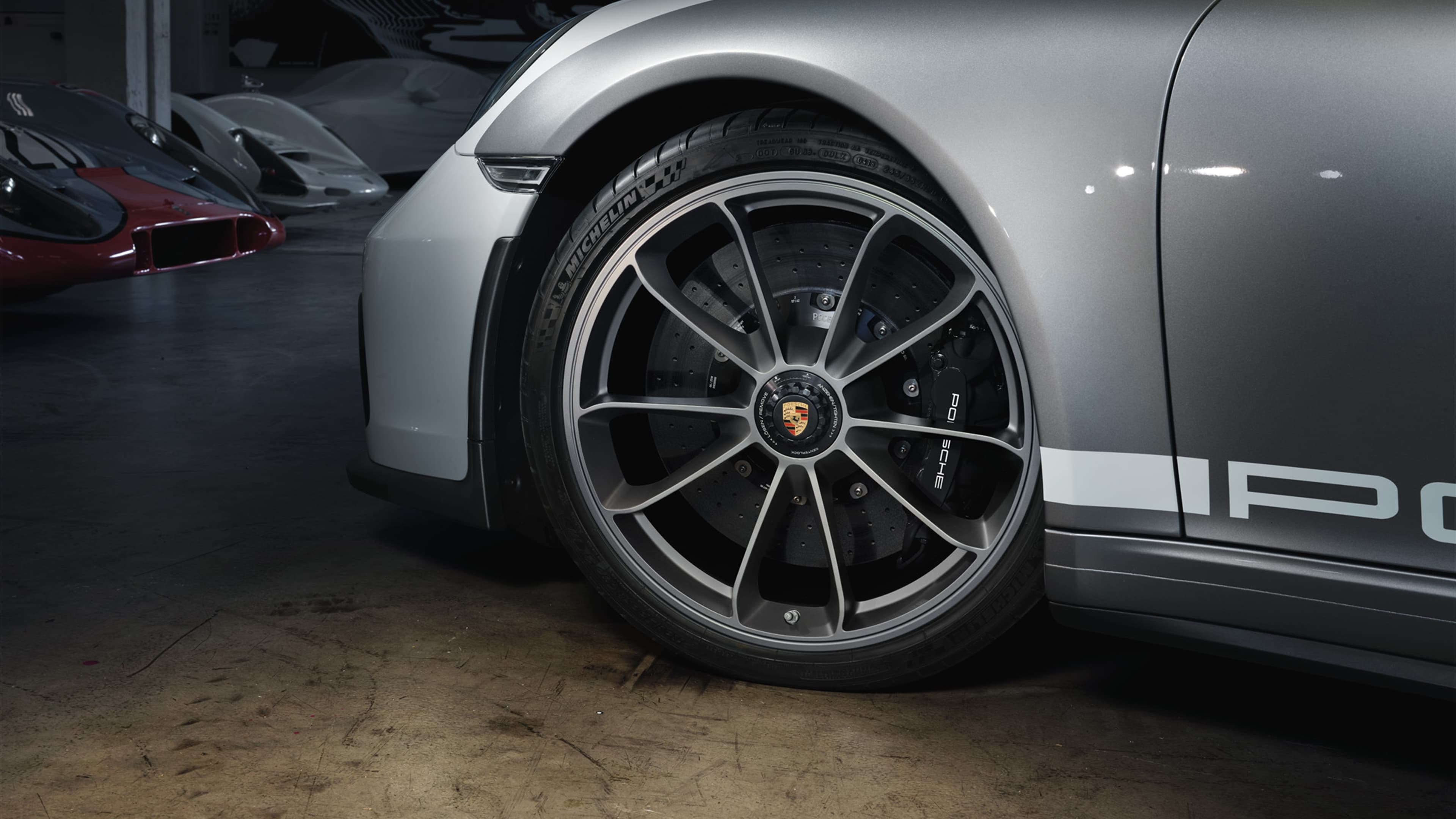 Widok z boku na szare Porsche 911 Speedster; zdjęcie jest przycięte, a felga wyróżniona.