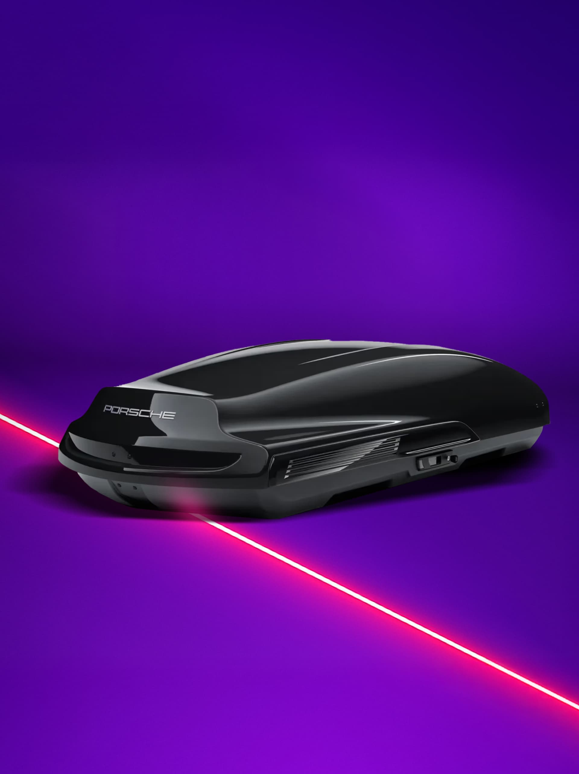 Sleek black Porsche roof box on a vibrant purple background with a red laser line.