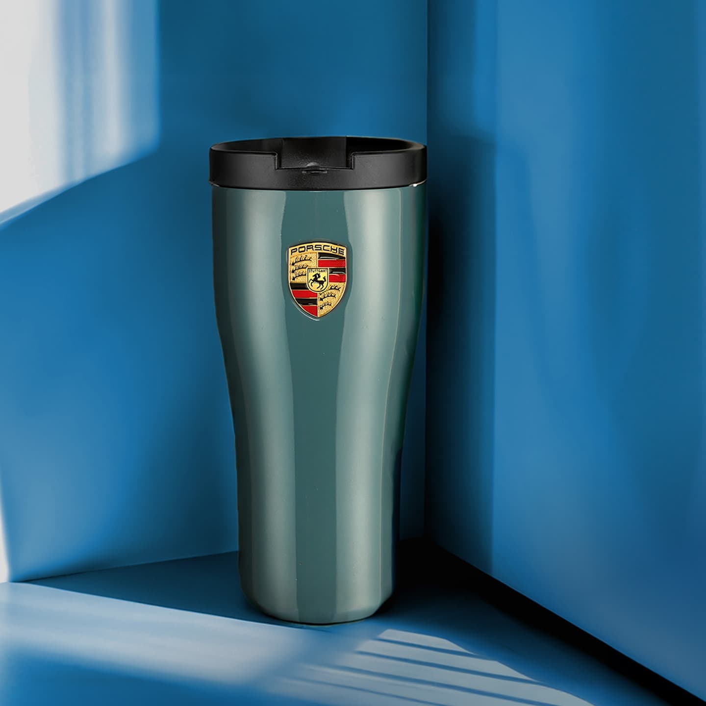 Porsche thermo mug in the focus on a blue background