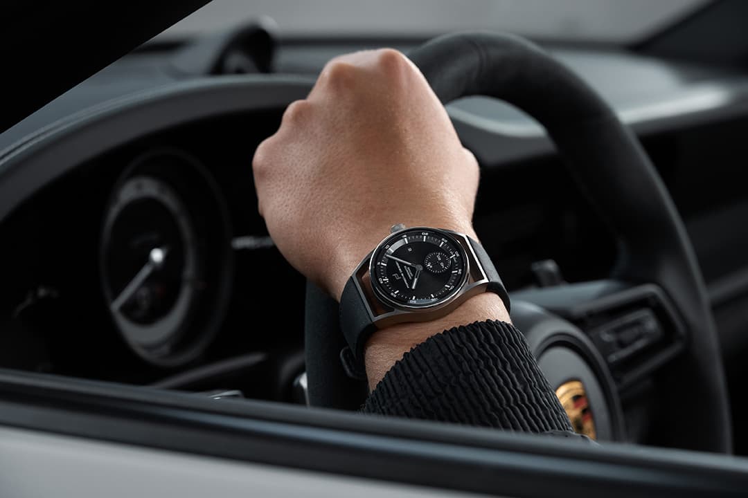 Detail shot from a mans wrist sitting in a car, wearing Porsche Design Timepiece from the Sport Chono Collection