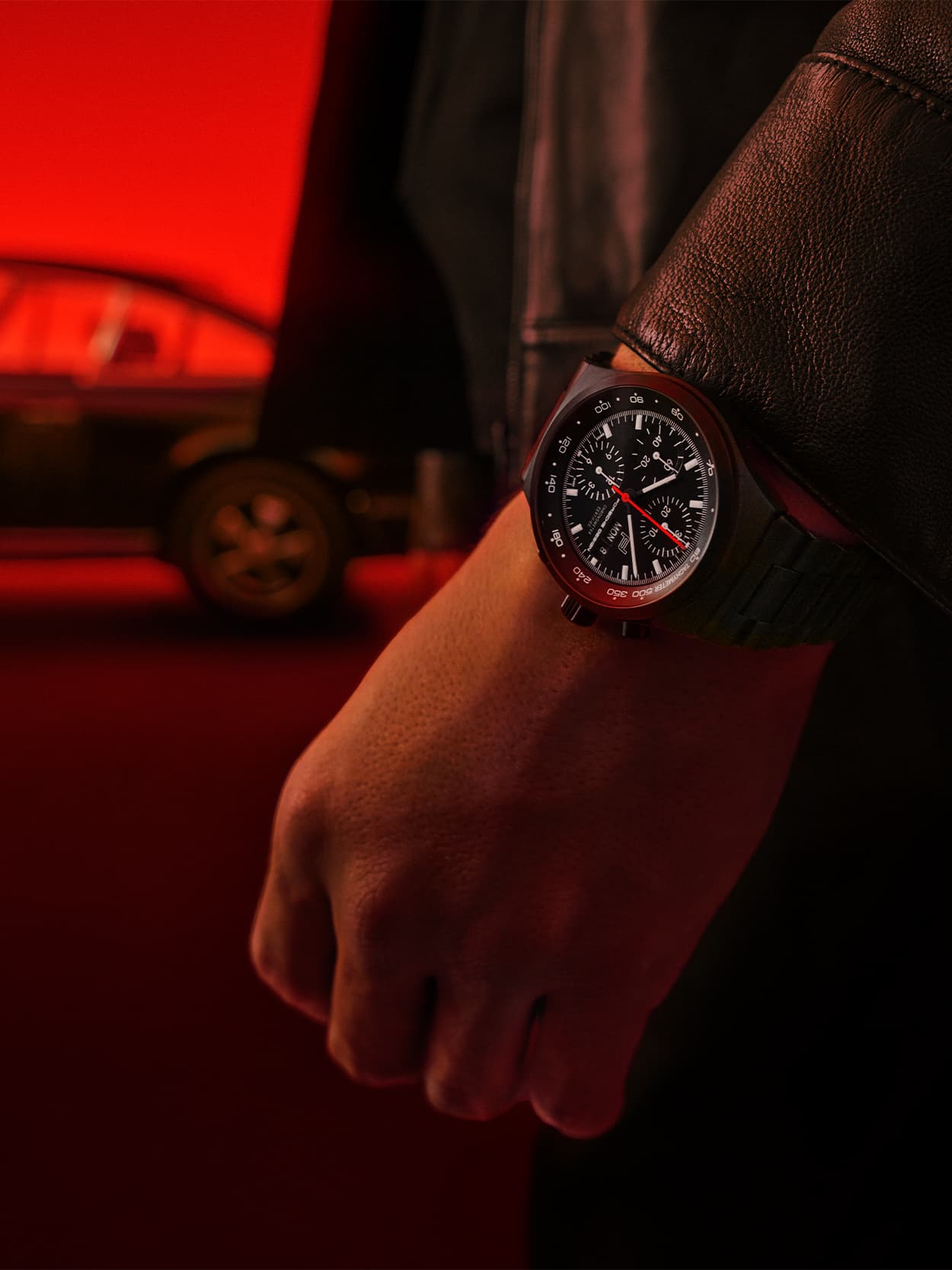 Close up of a Porsche Design Chronograph 1 with a person in a red environment