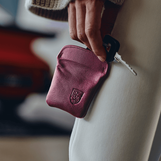 You can see a woman holding a dark red Porsche key chain