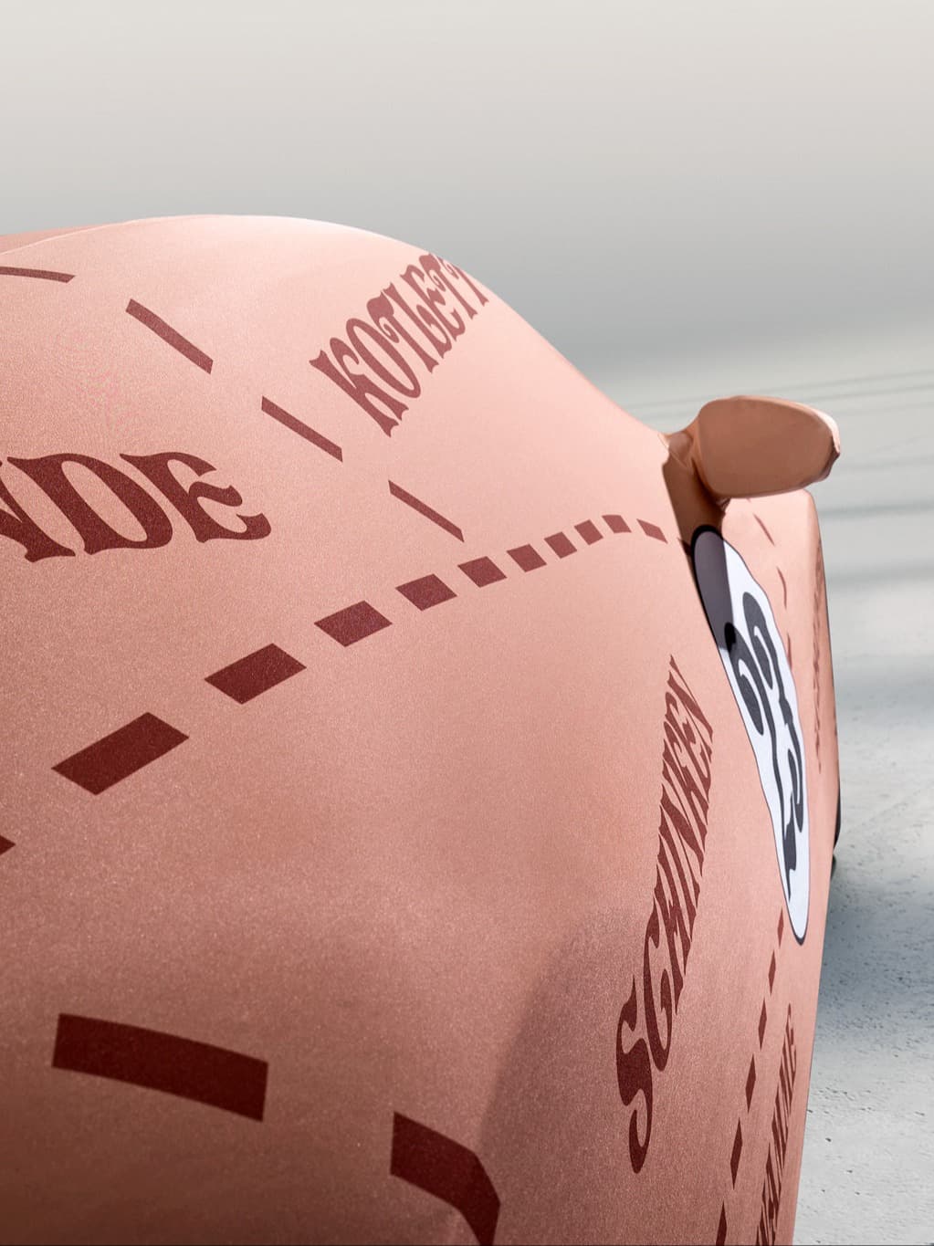 Detailní záběr na růžový model Porsche se startovním číslem 23 a nápisem „Schwarzwald“ na karoserii.