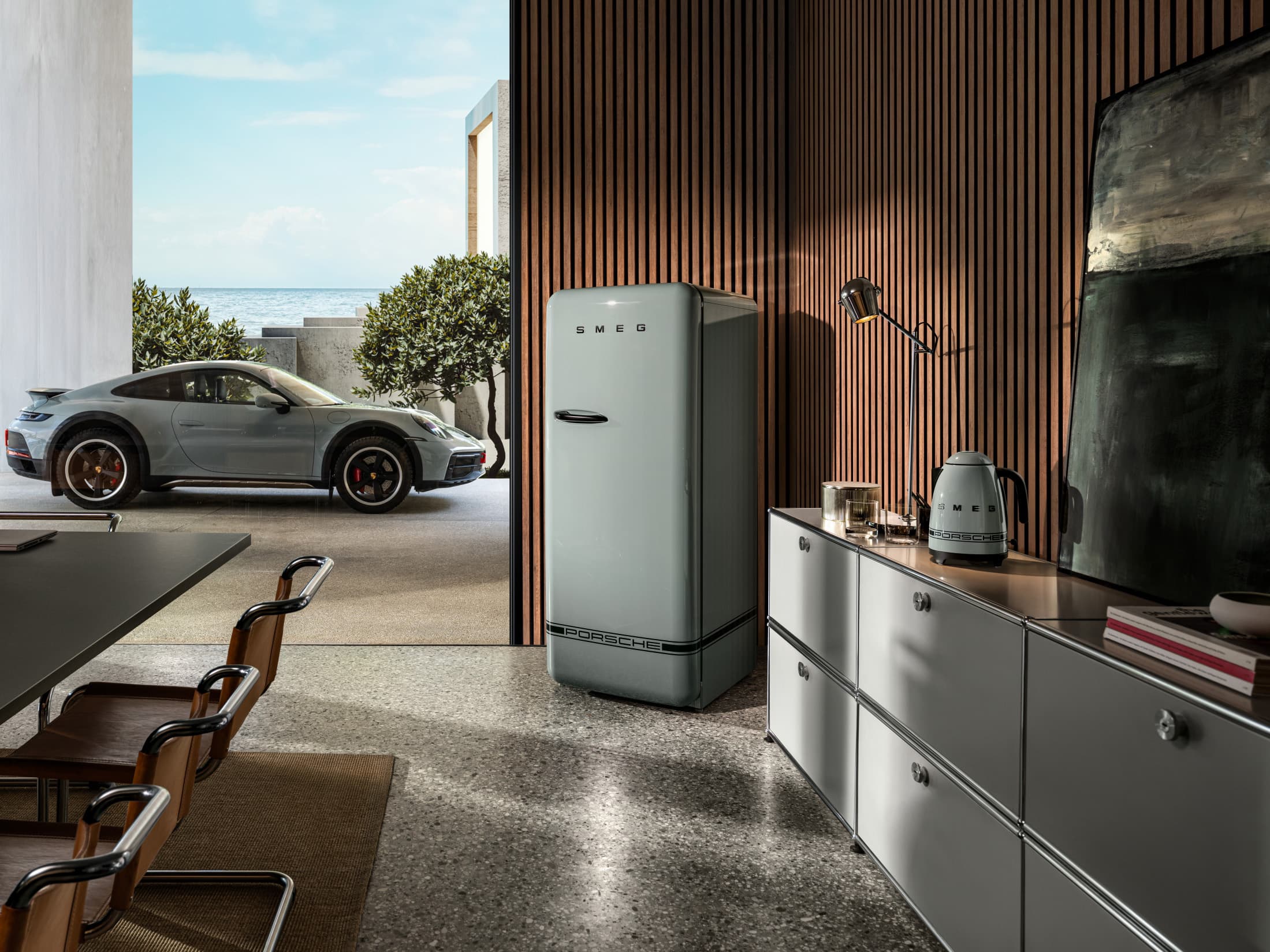 Porsche x Smeg refrigerator in a living room setting with a view of a winter landscape