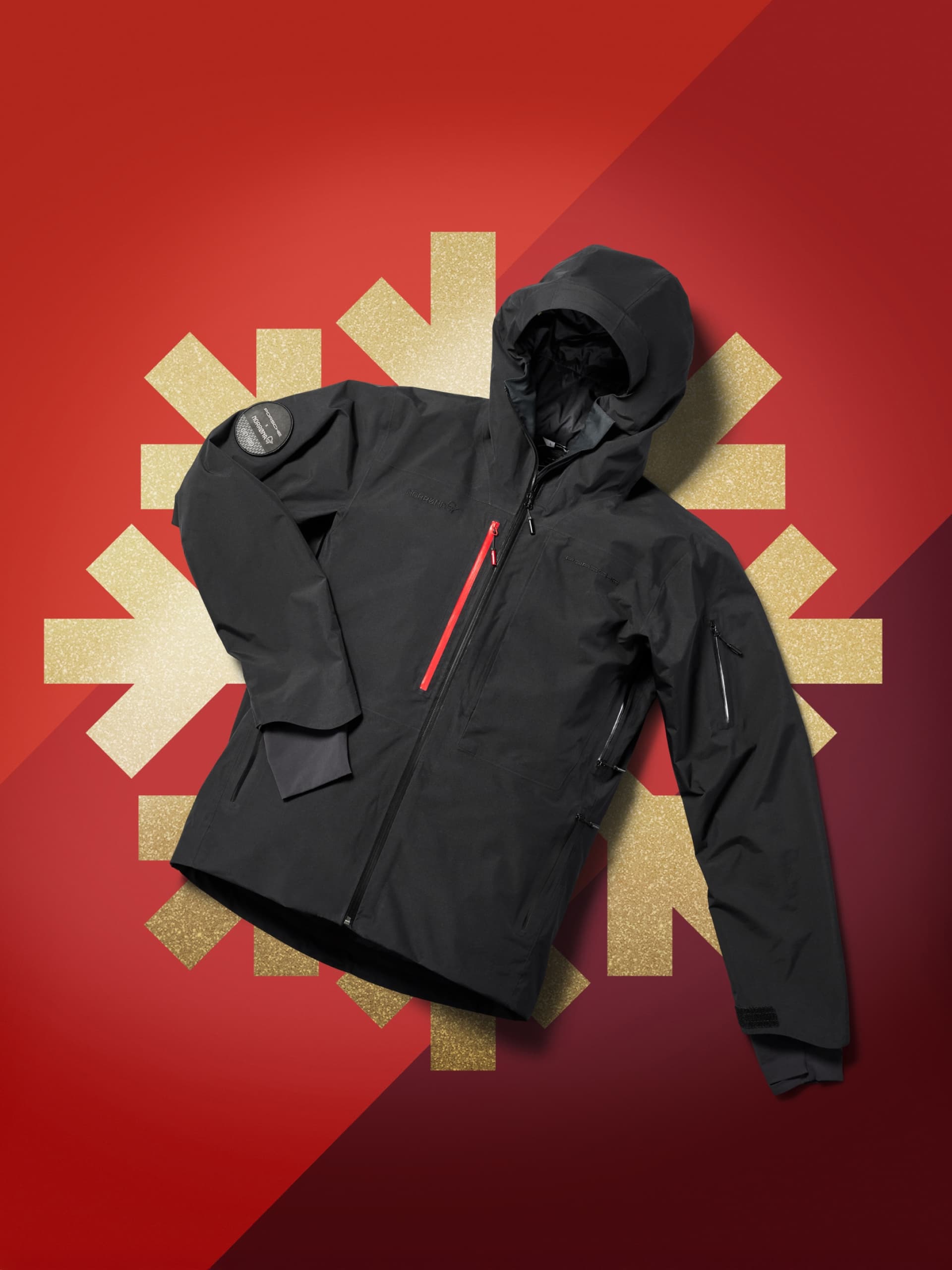 Schwarze Jacke auf goldenem Schneeflockenhintergrund.