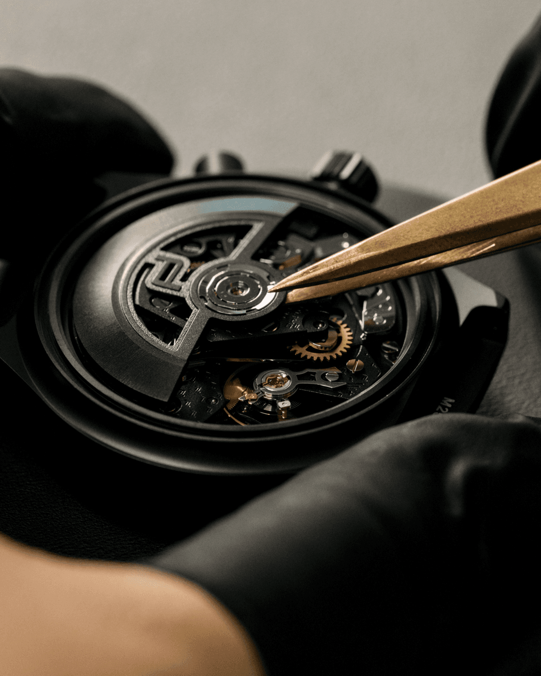 Zbliżenie na zegarmistrza regulującego mechanizm chronografu Porsche Design