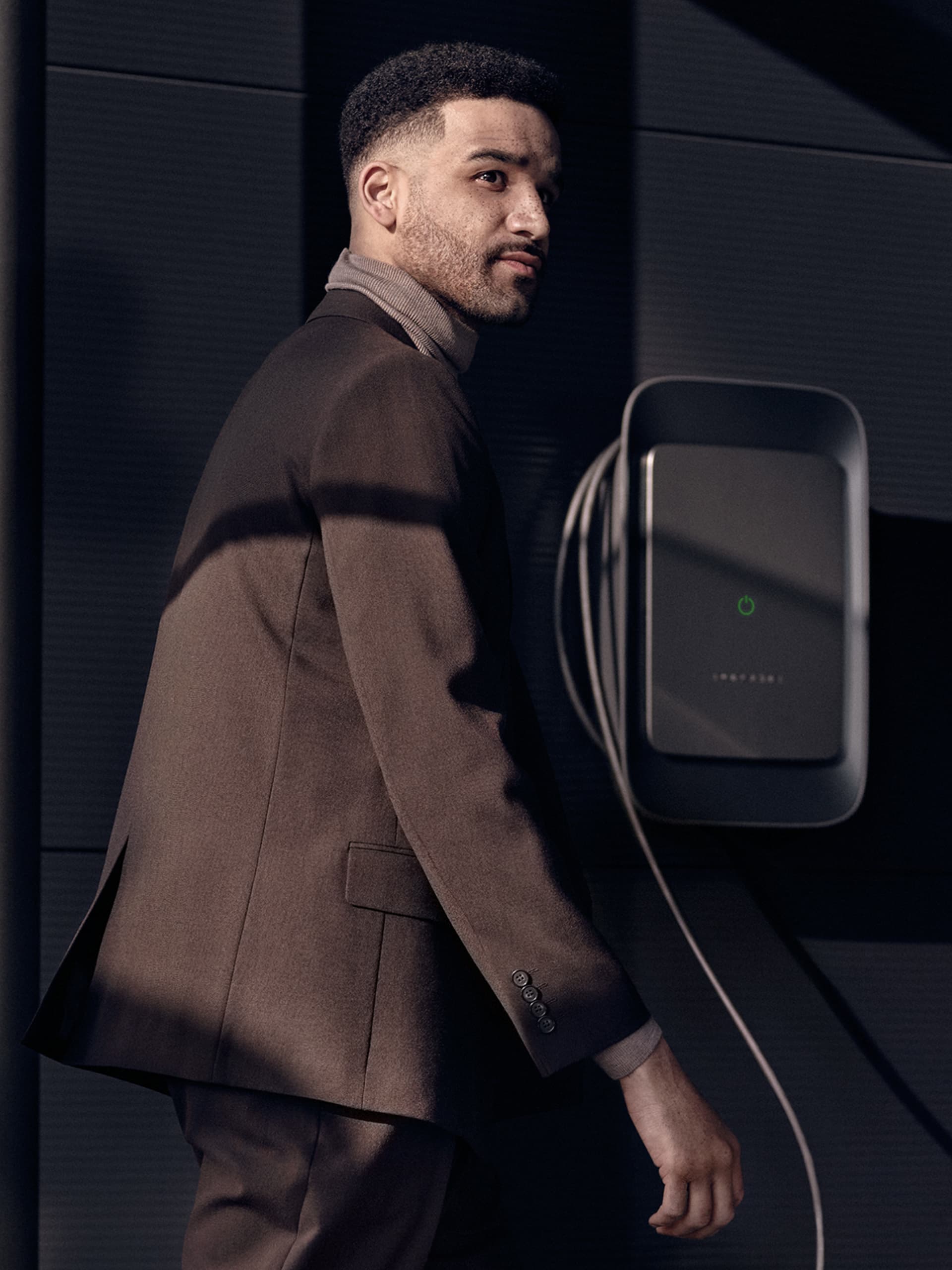 You can see a man walking next to a Porsche Wallbox