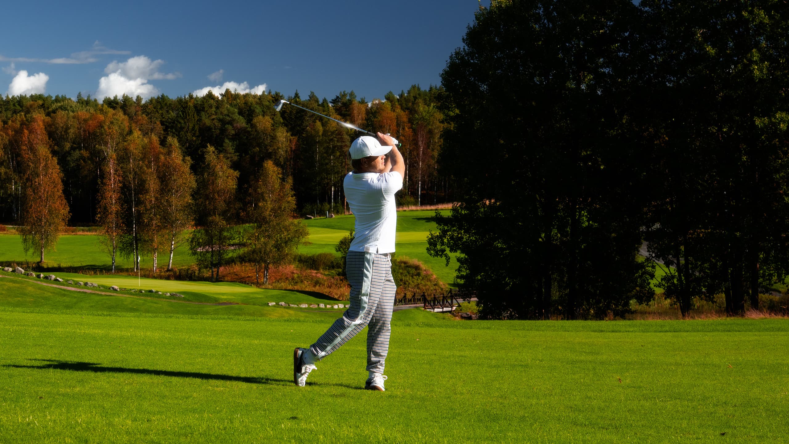 Man playing golf on golf couse, wearing the Porsche Targa 911 Golf Collection