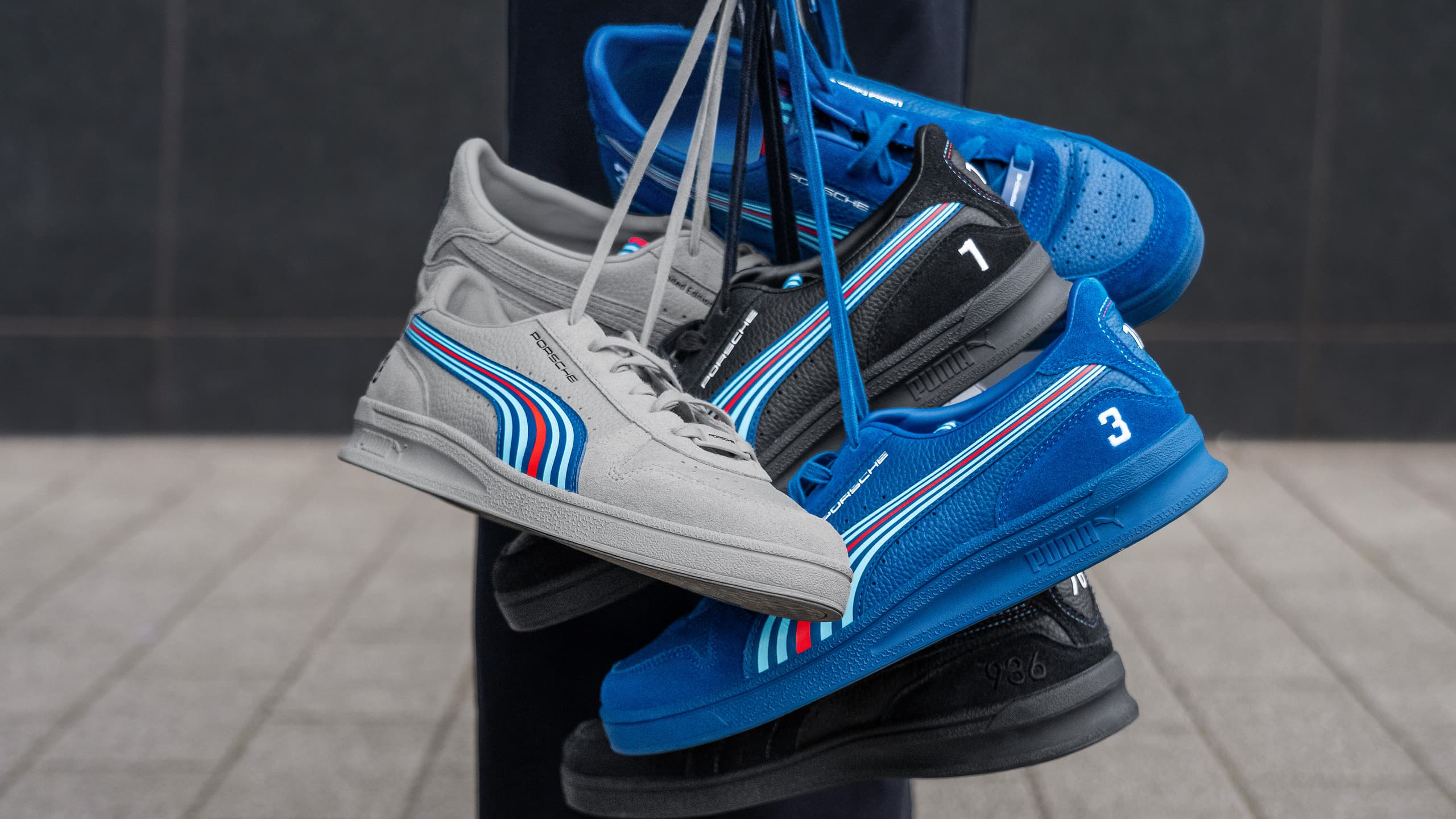 Woman holding a bundle of limited edition sneakers from the Porsche x Martini Racing collection