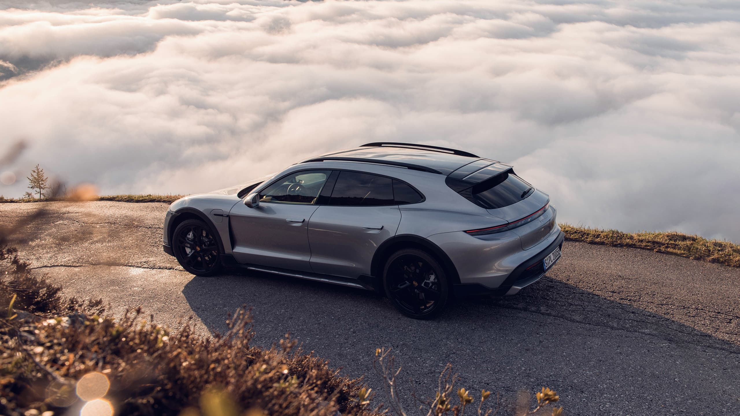 You can see a Porsche Taycan on a street in the mountains