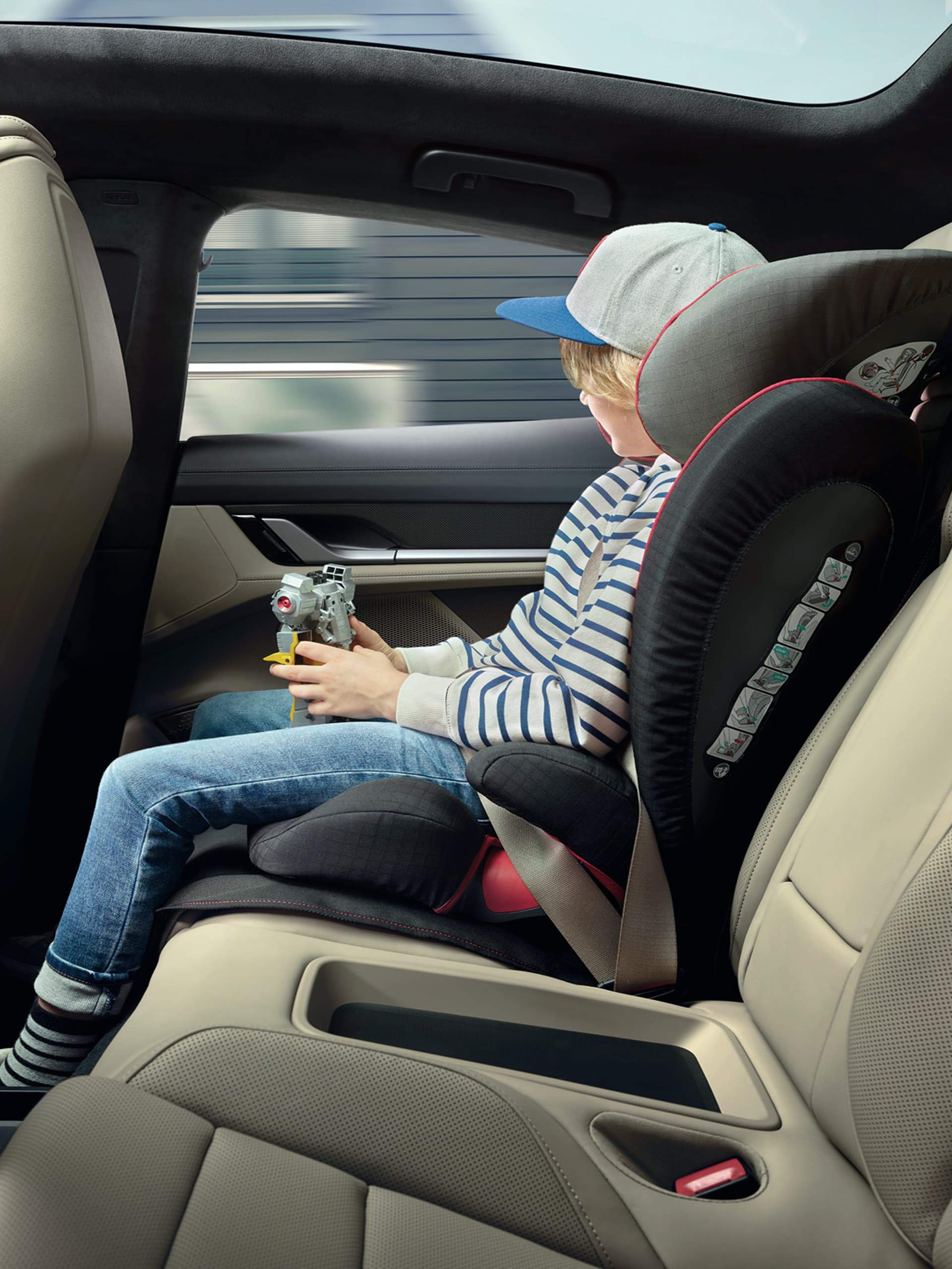 You can see a child sitting in the back of a car in a Porsche child seat
