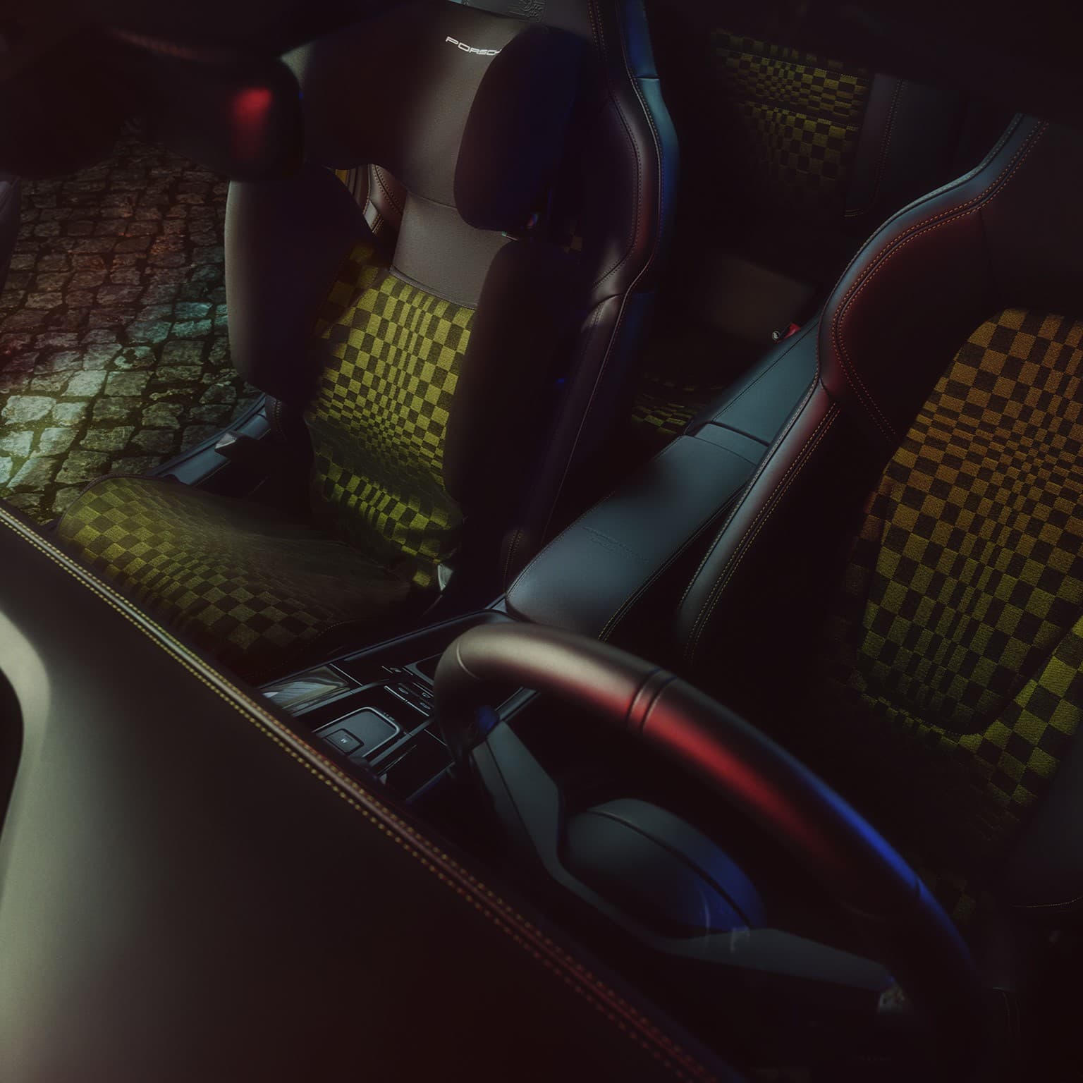 Car interior with black leather seats and green checkered pattern, illuminated by ambient light, cobblestone street visible outside.
