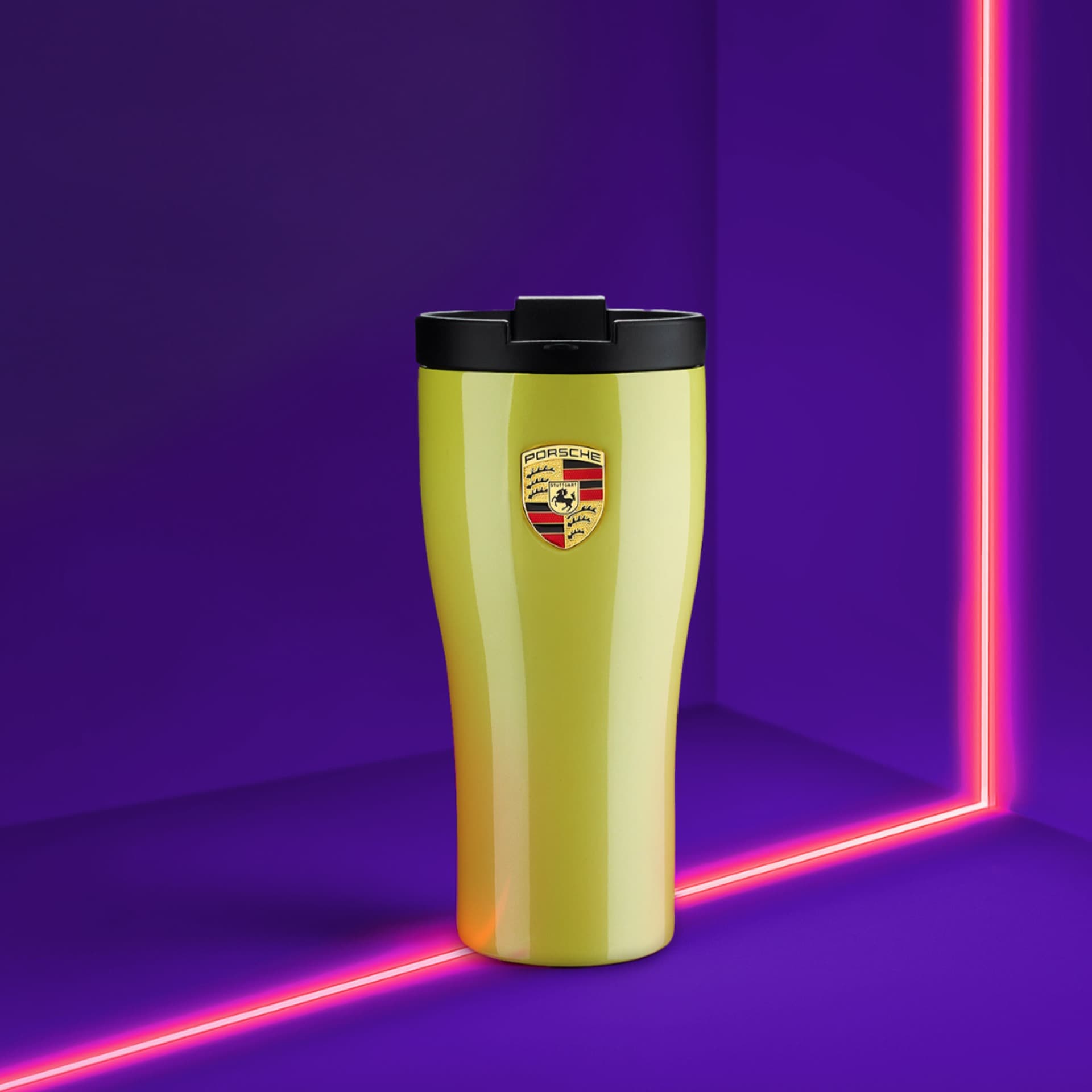 Yellow Porsche travel mug with black lid, logo on front, set against a vibrant purple background with pink neon lines