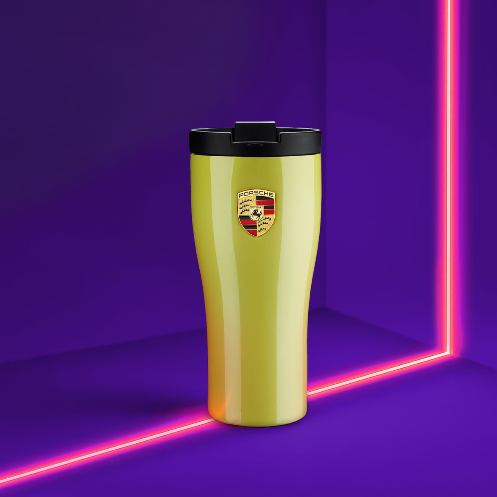 Yellow Porsche travel mug with black lid, logo on front, set against a vibrant purple background with pink neon lines.