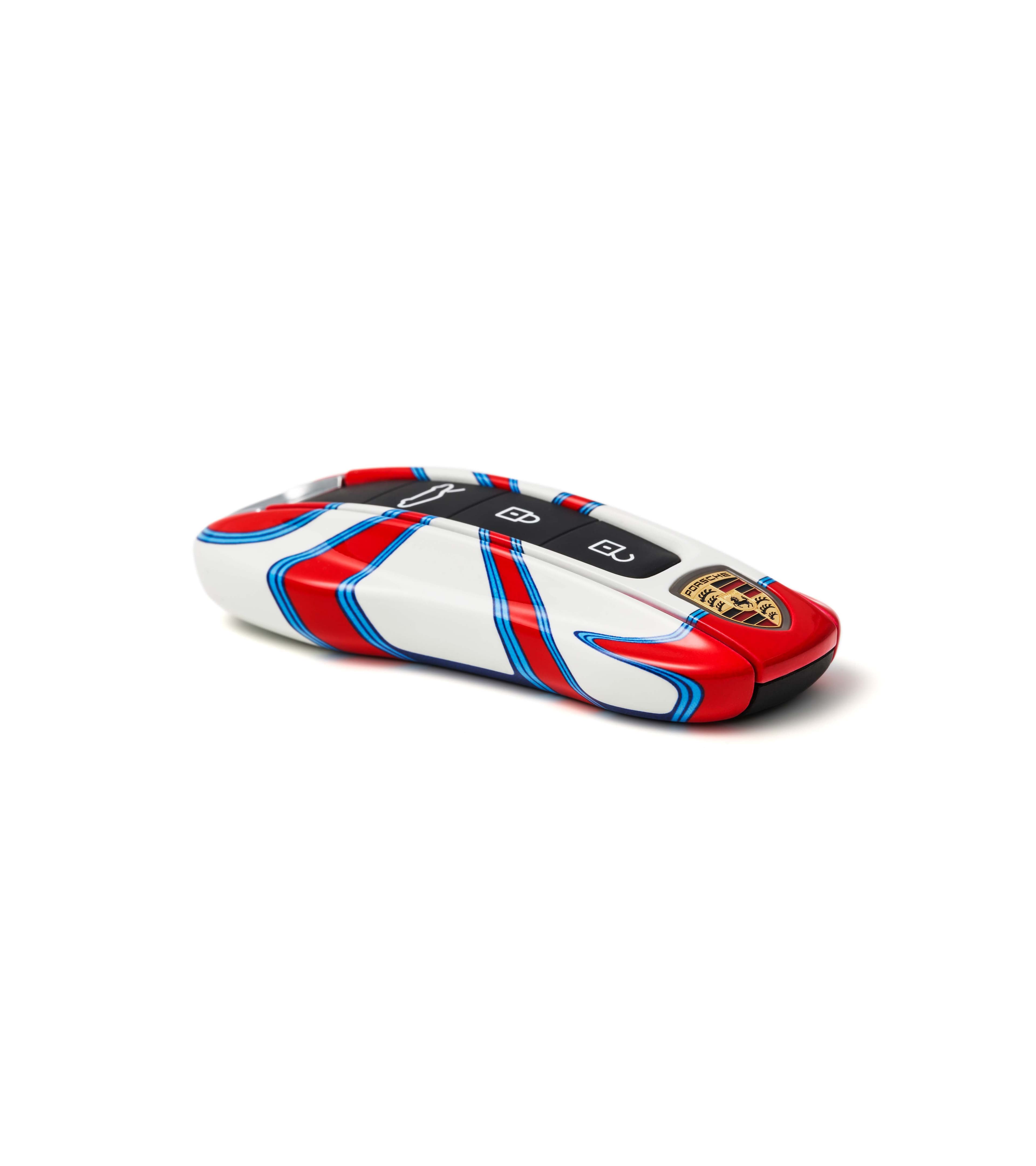 Porsche key fob with red, blue, and white racing stripes on a white background.