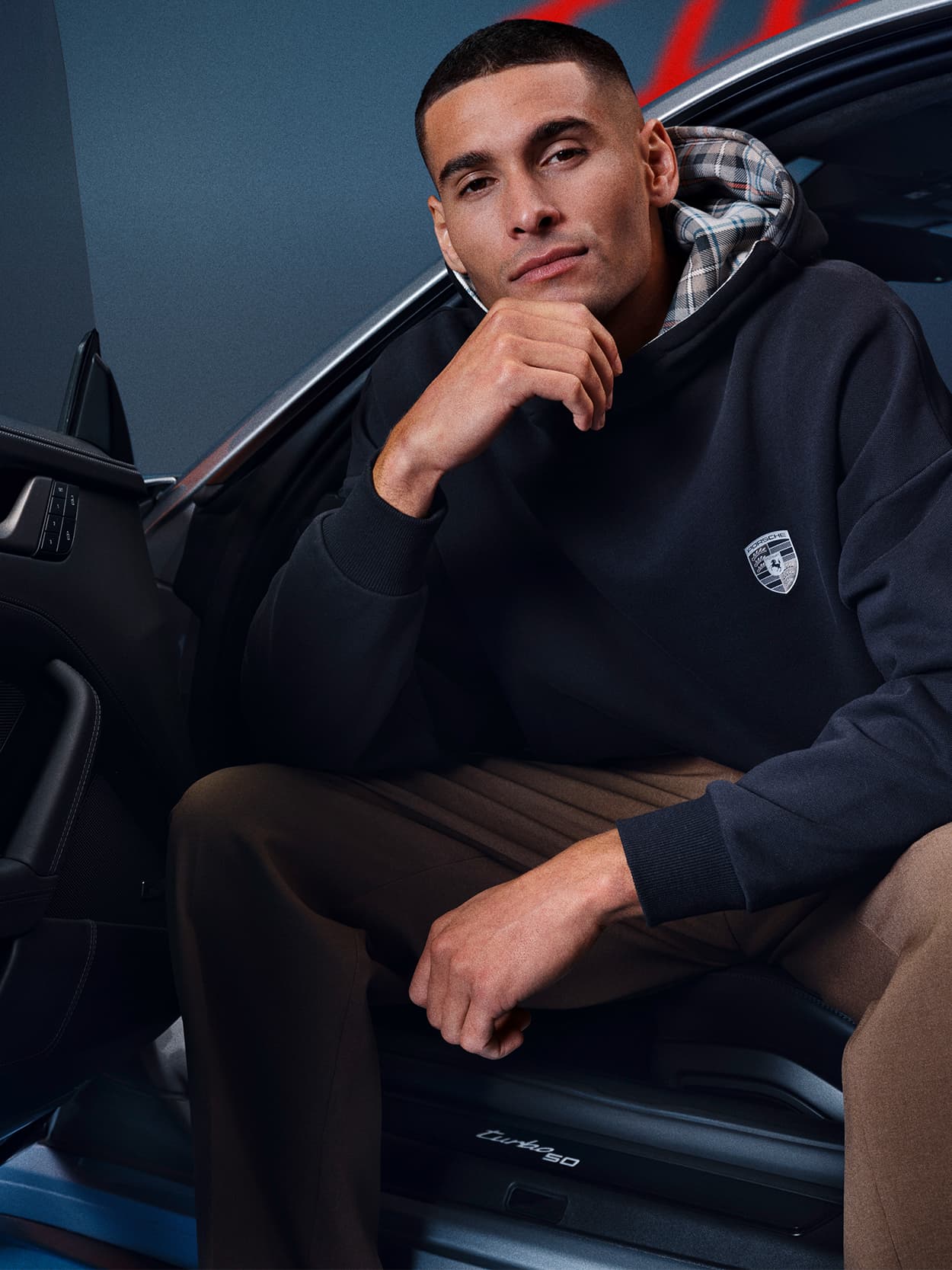 Man sitting in the car with open door wearing Turbo No. 1 clothing