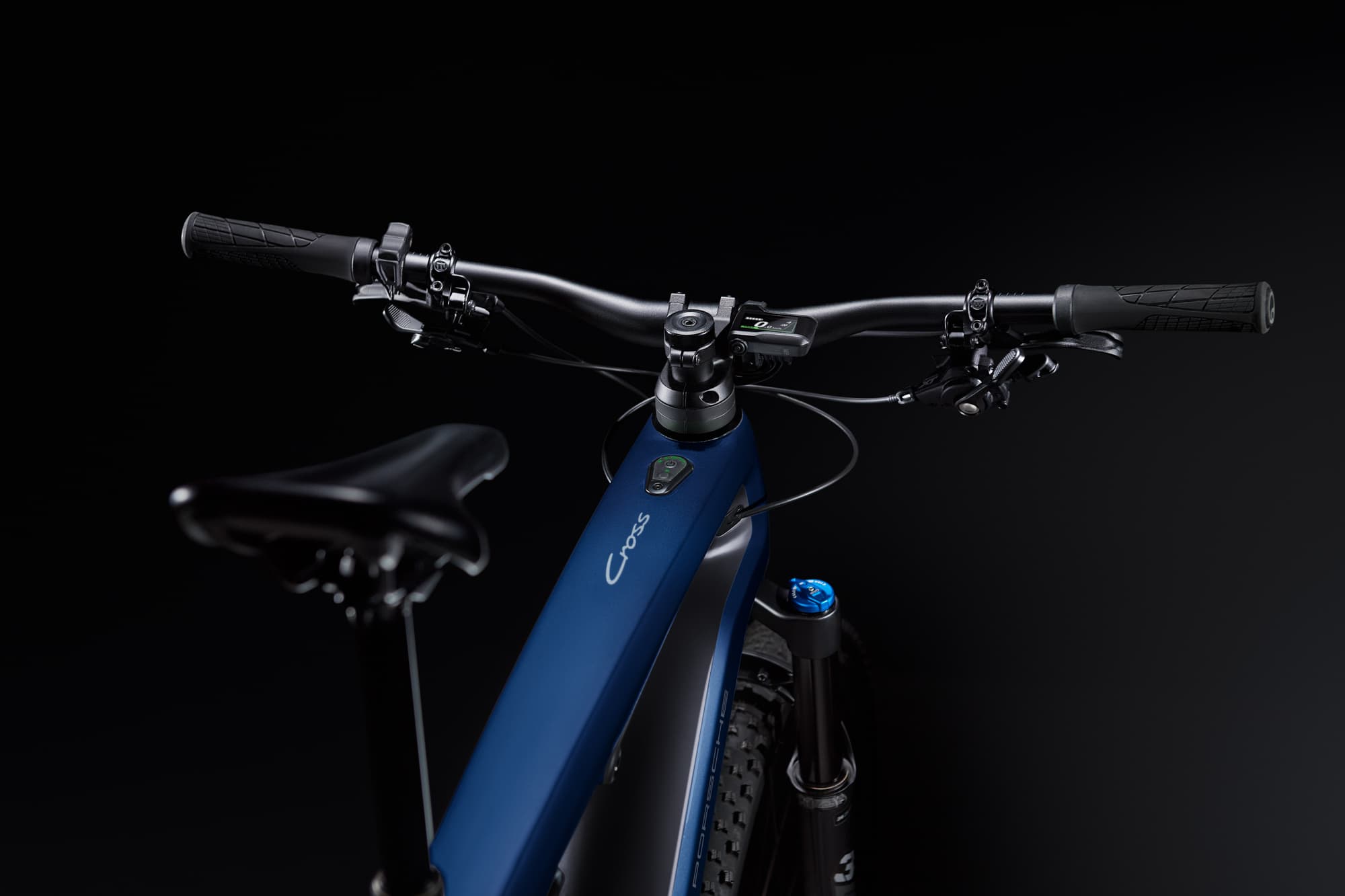 Zbliżenie na niebieski rower elektryczny Porsche eBike Cross leżący na ziemi