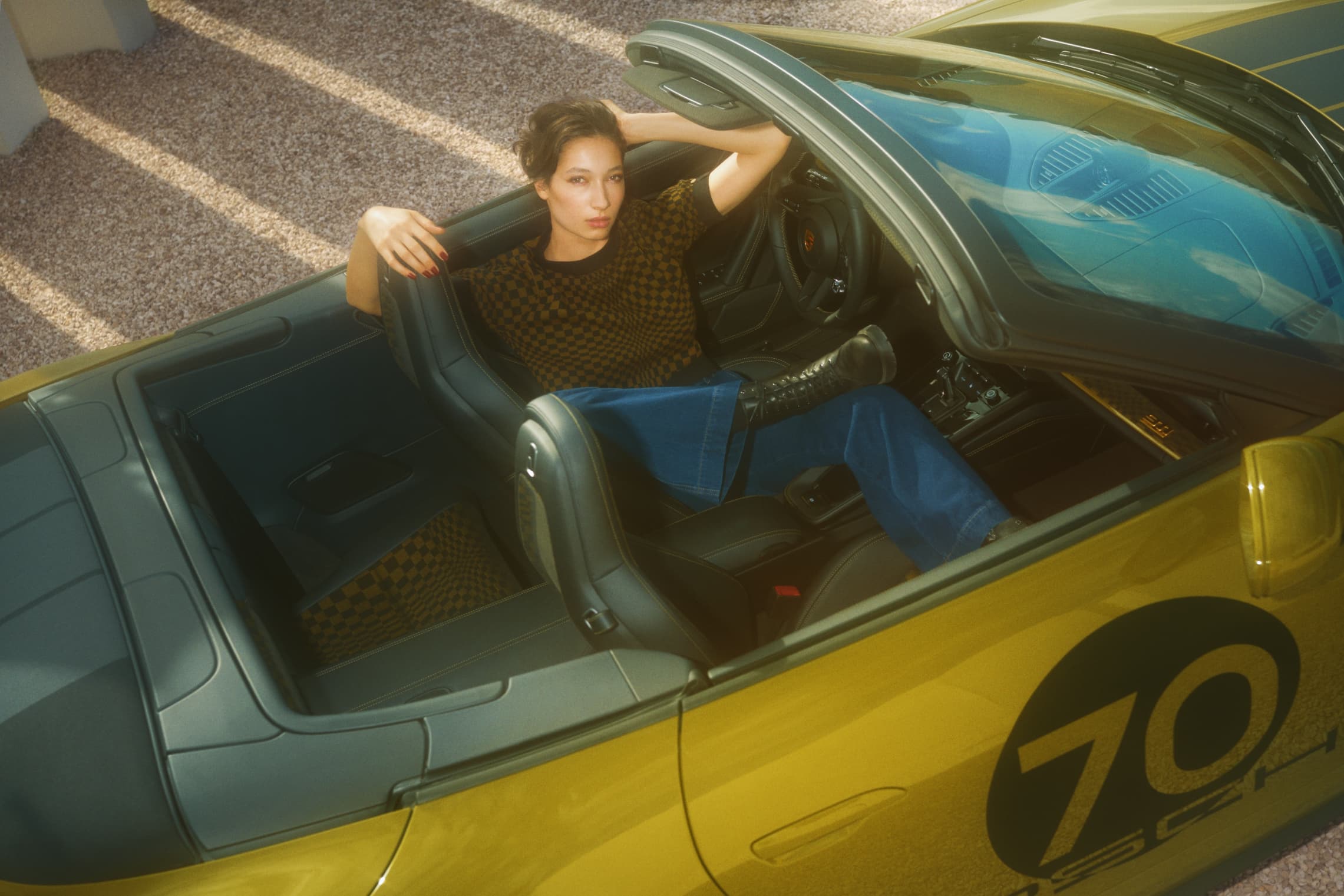 Woman wearing clothing from the 911 Spirt 70 Collection. sitting in an Posche Cabrio.