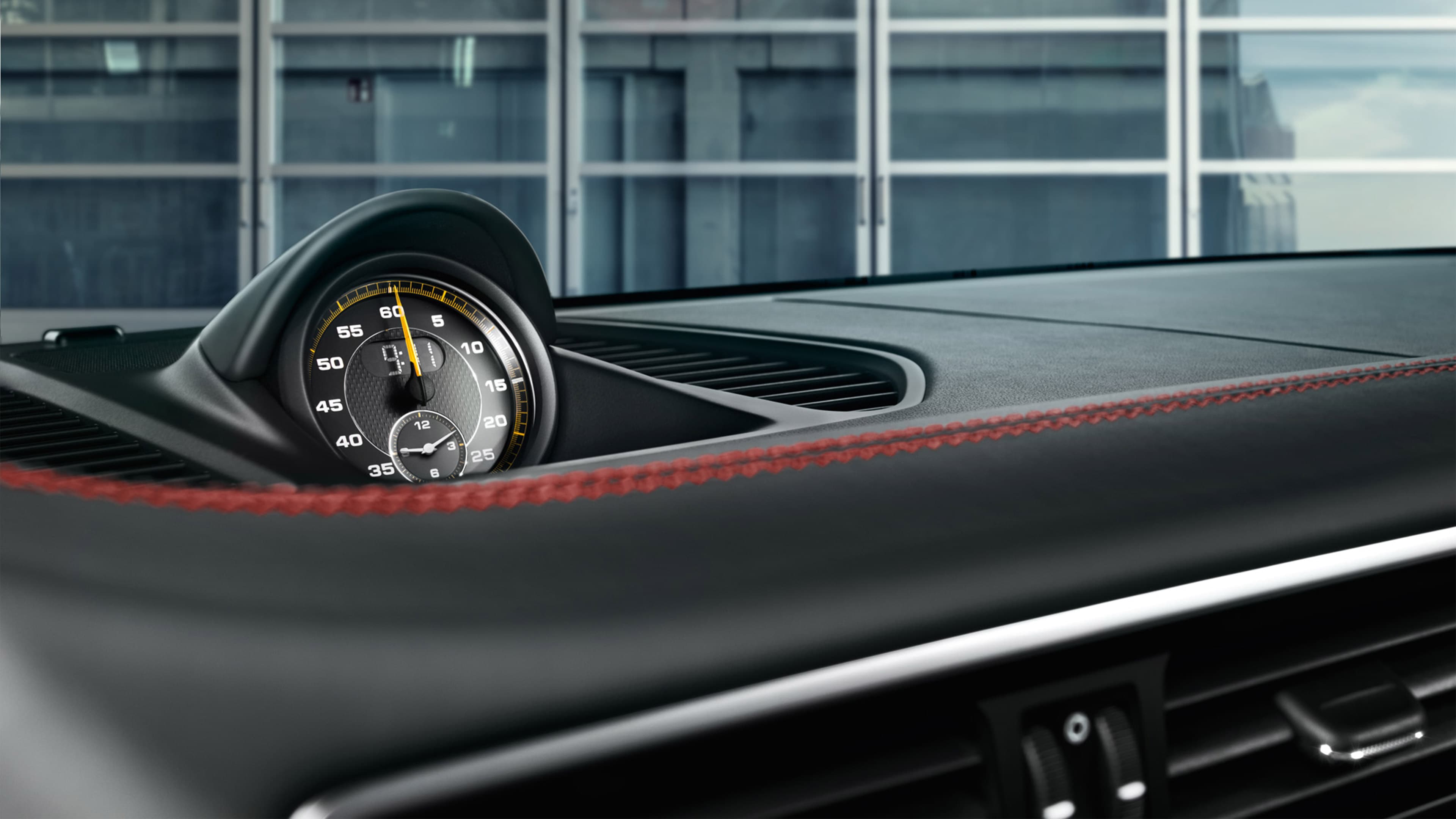 Na środku deski rozdzielczej Porsche GT2 RS widoczny jest analogowy zegar lub chronograf.