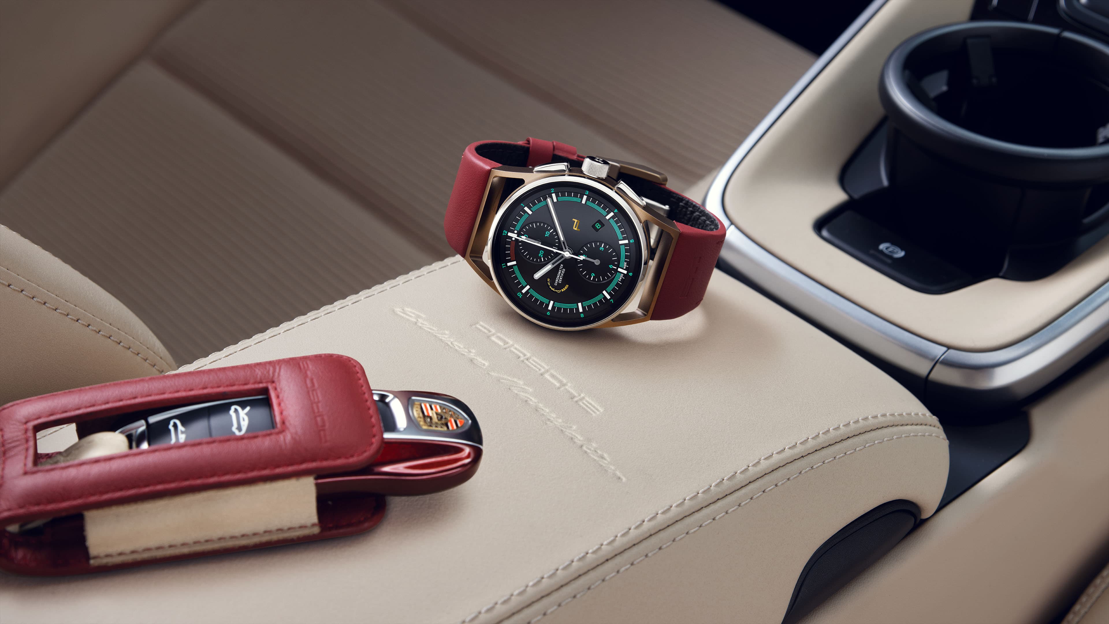 Pictured is the Chronograph 911 Targa 4S Heritage Design Edition with red strap and a Porsche car key on a beige leather background in a Porsche car