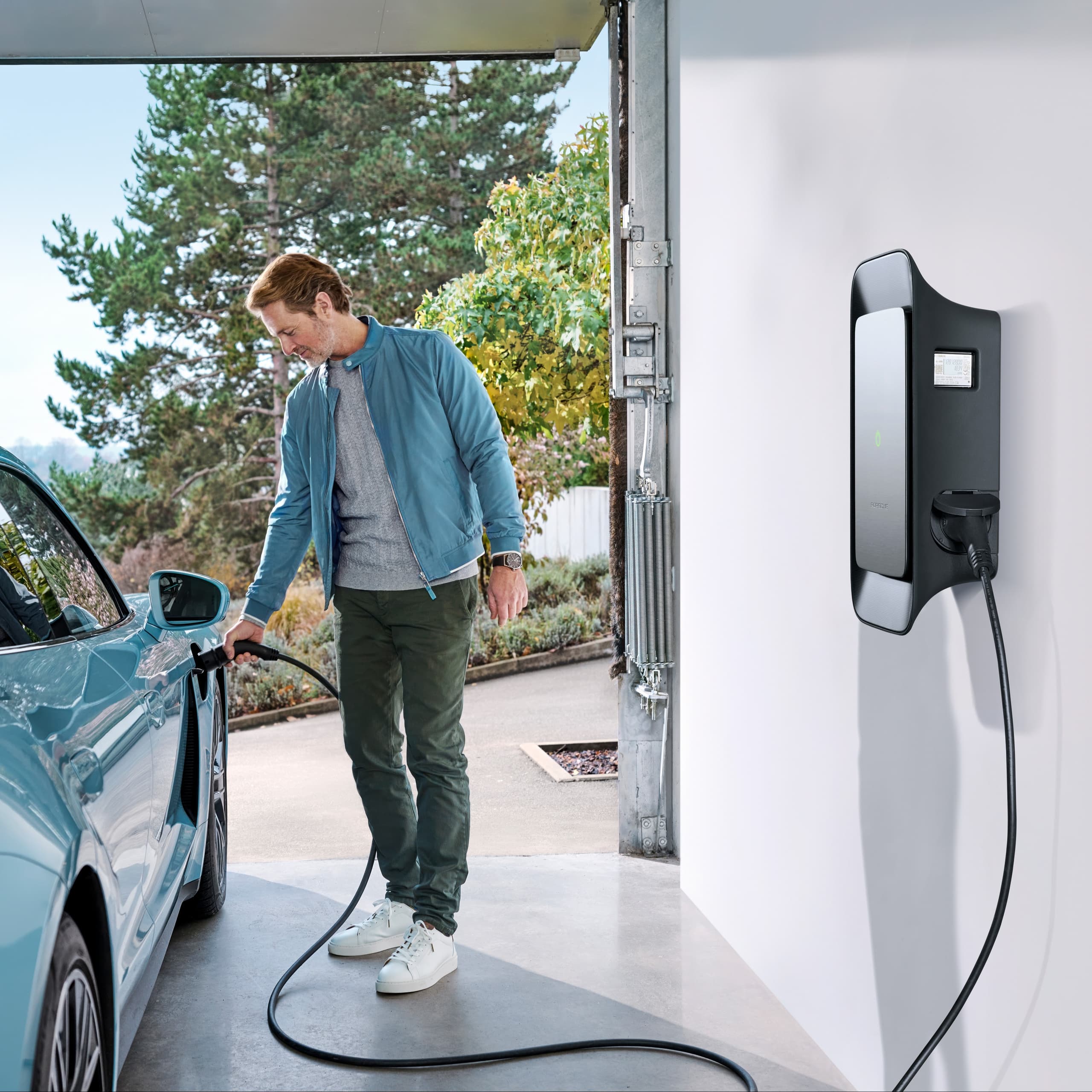 Man in a garage with a Porsche Wallbox