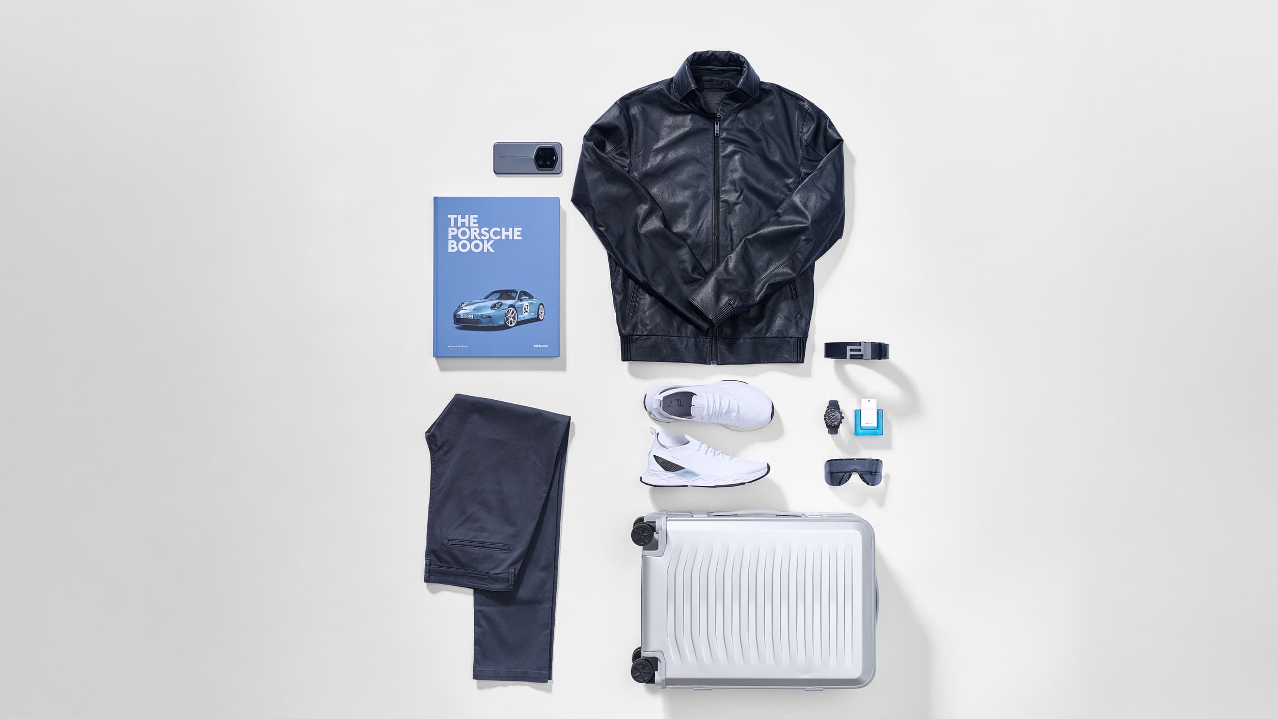 Flatlay arangement of Porsche Design Fashion an Luggage Products