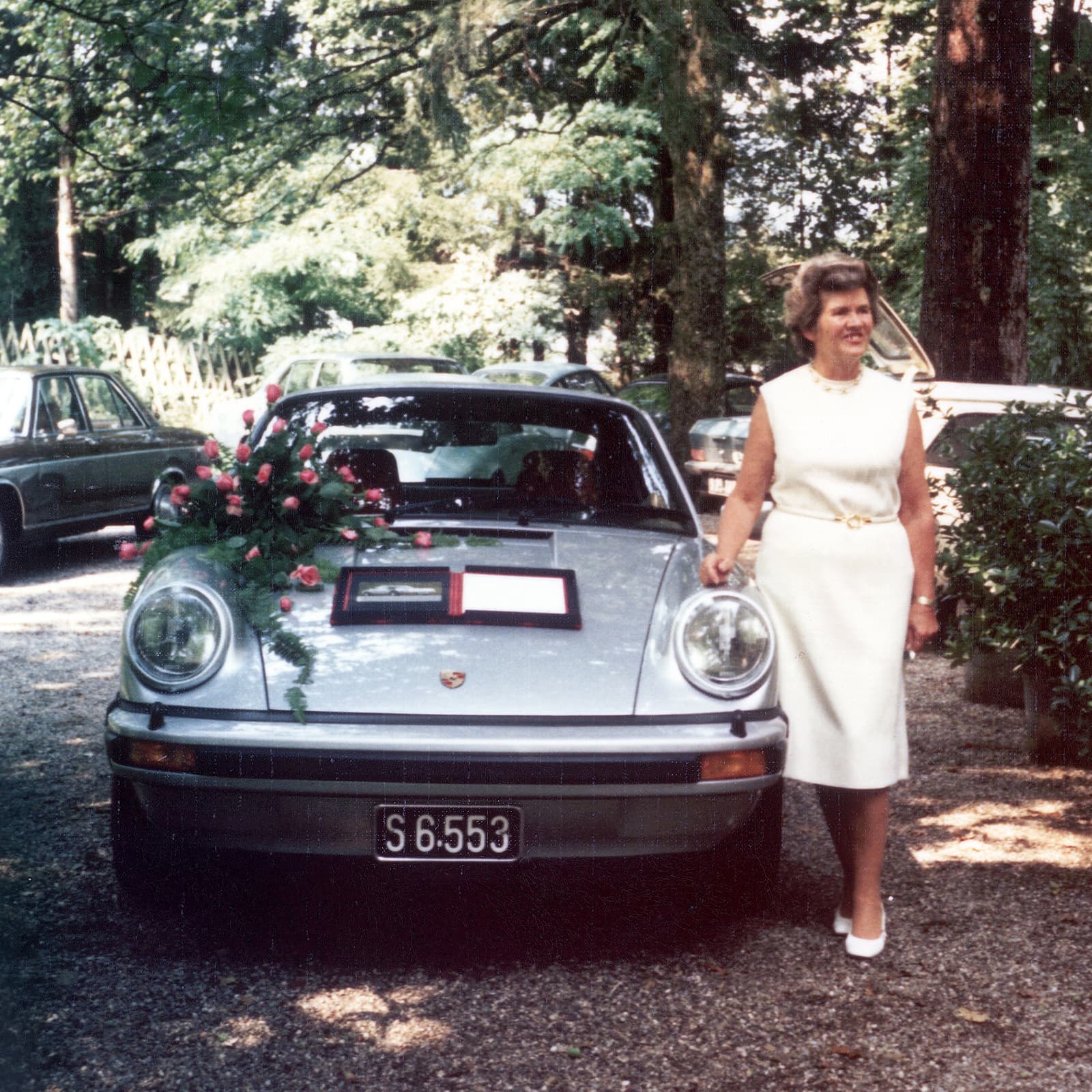 Louise Piëch standing next to a Porsche 911 Turbo in silver