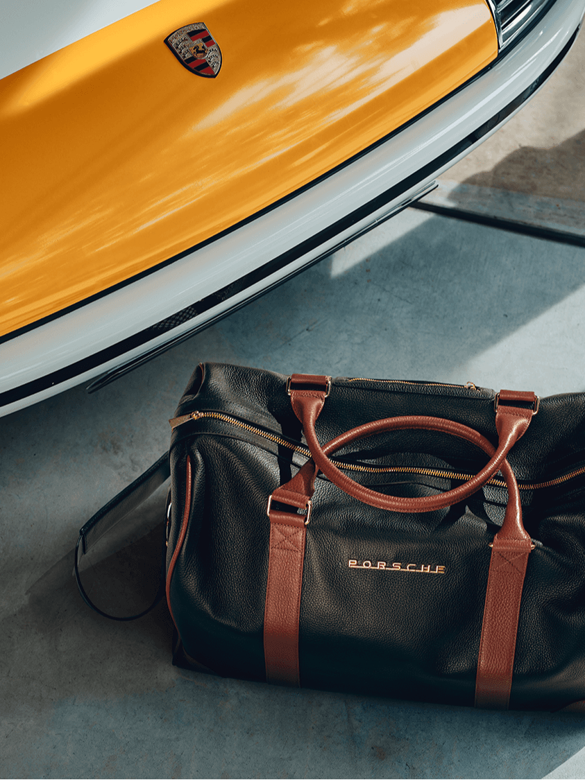 You can see a Porsche Touring bag next to a historic Porsche 911