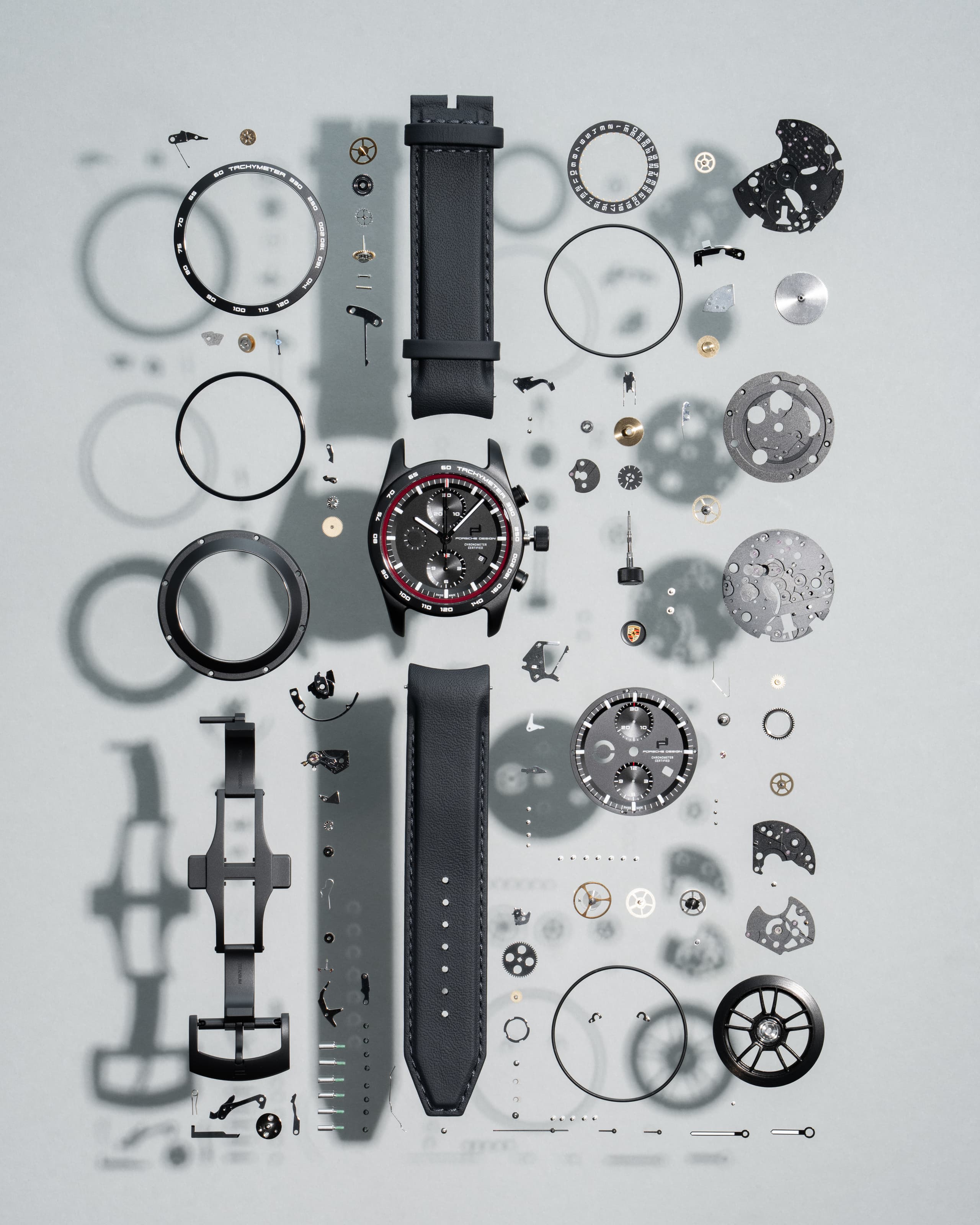 Image shows a Porsche Design watch disassembled into its individual parts.