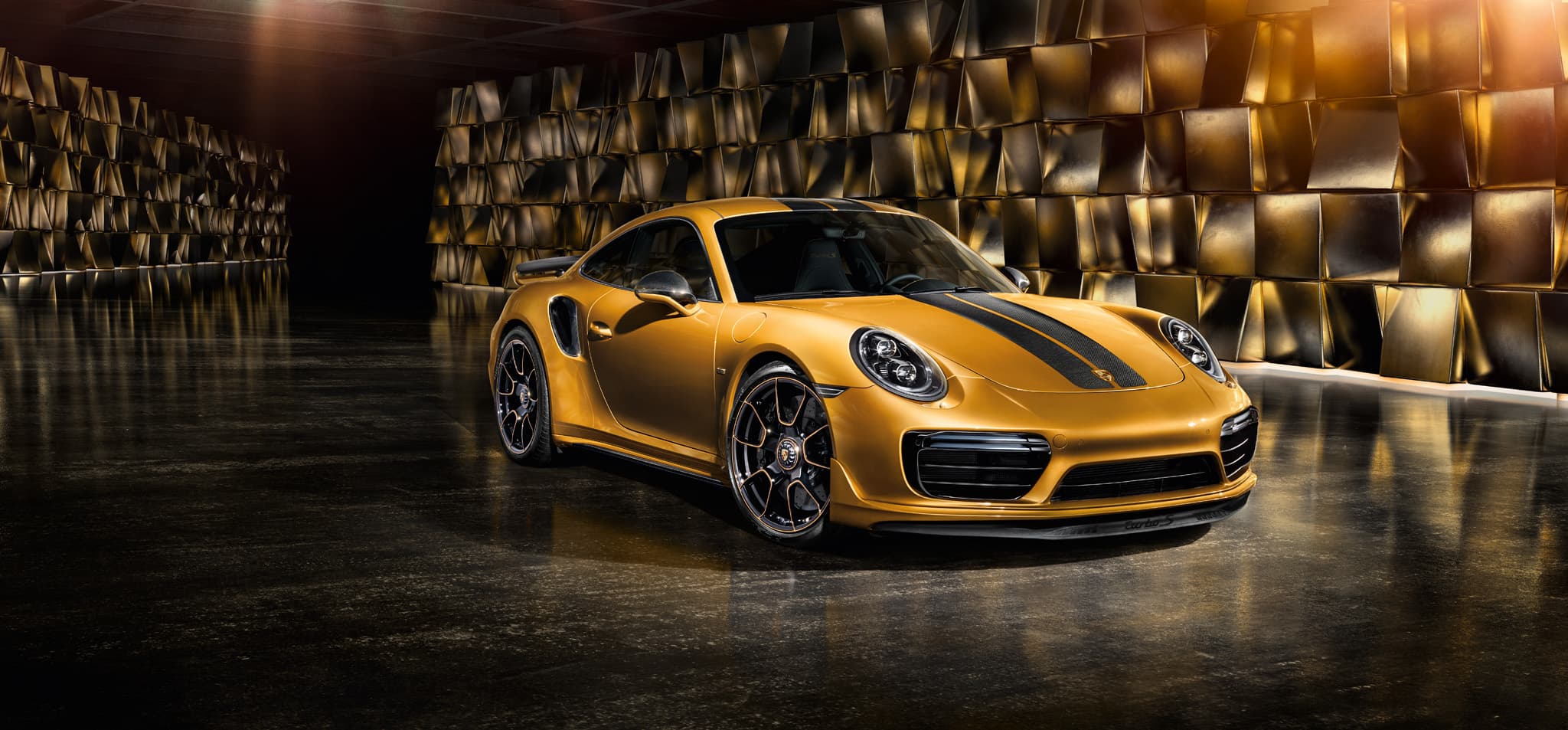 Goldener Porsche 911 Turbo S mit schwarzen Streifen abgebildet.