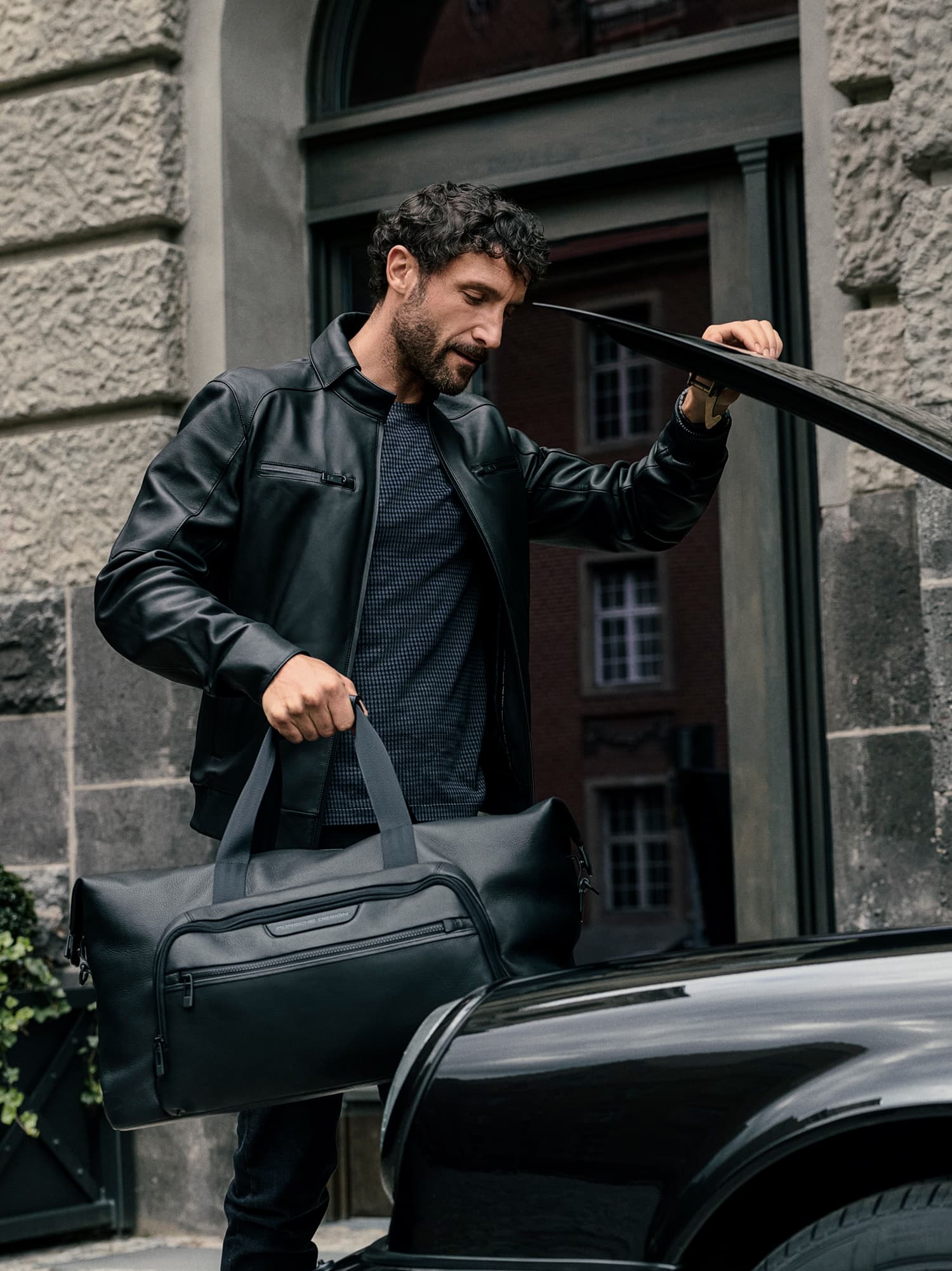 Two men carrying Porsche Design Luggage