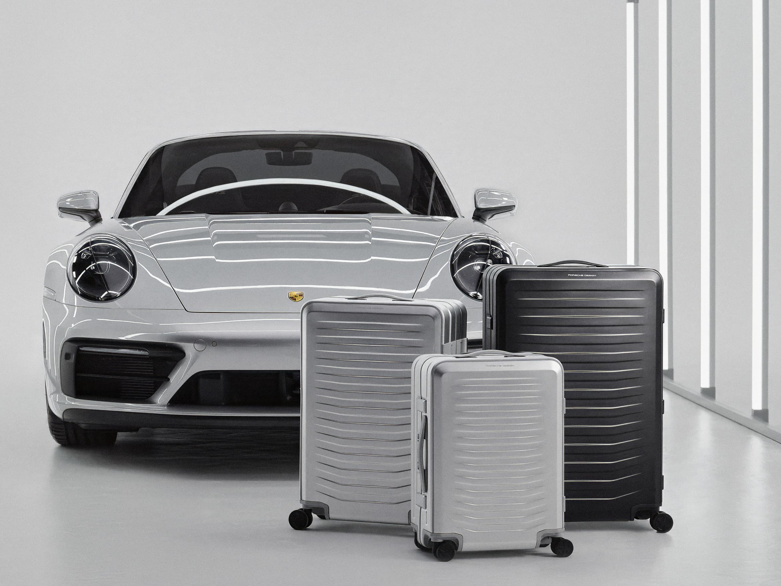 Porsche Design Roadster Aluminum Product Range in front of Porsche car