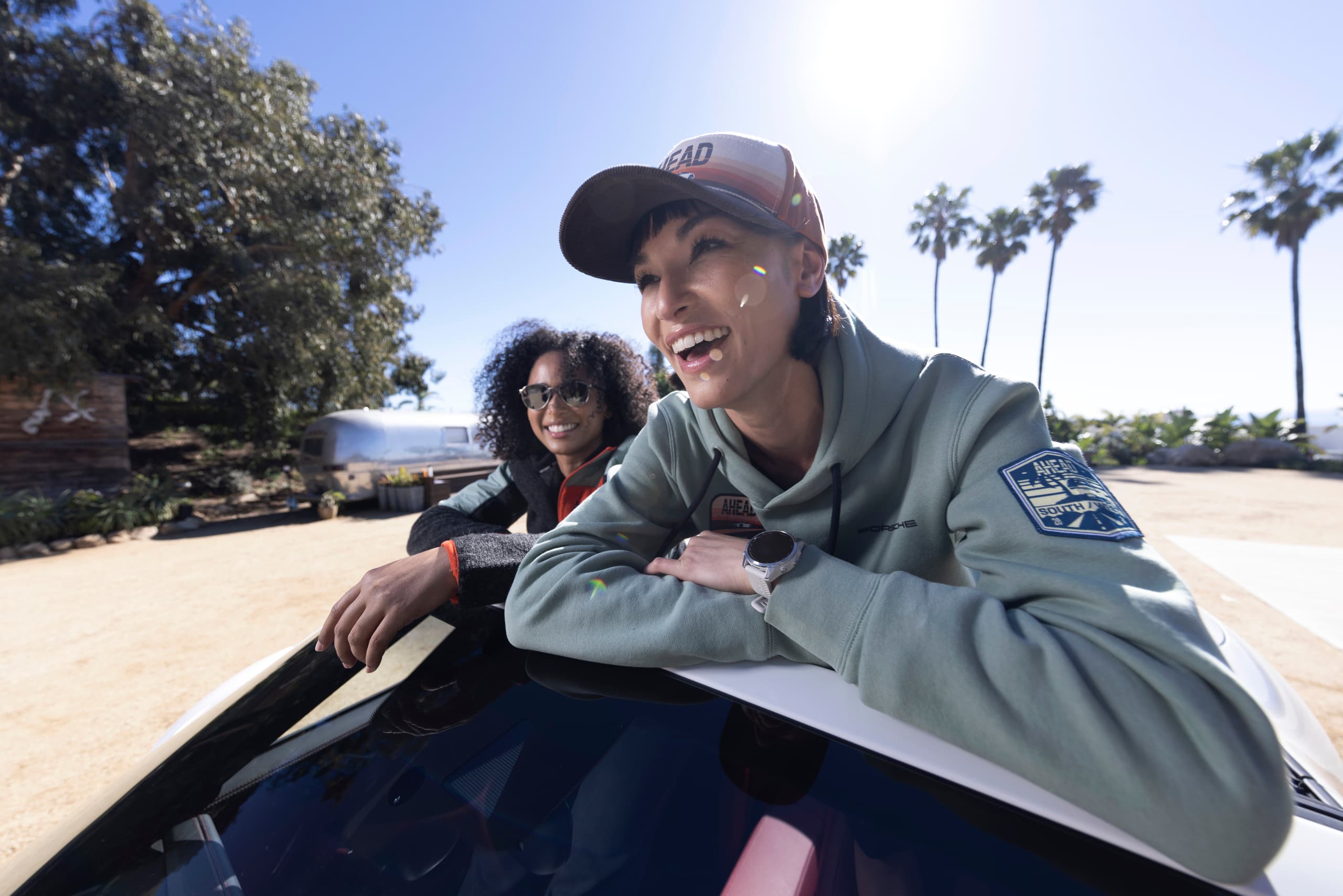 Two women in a car wearing products of the new AHEAD collection