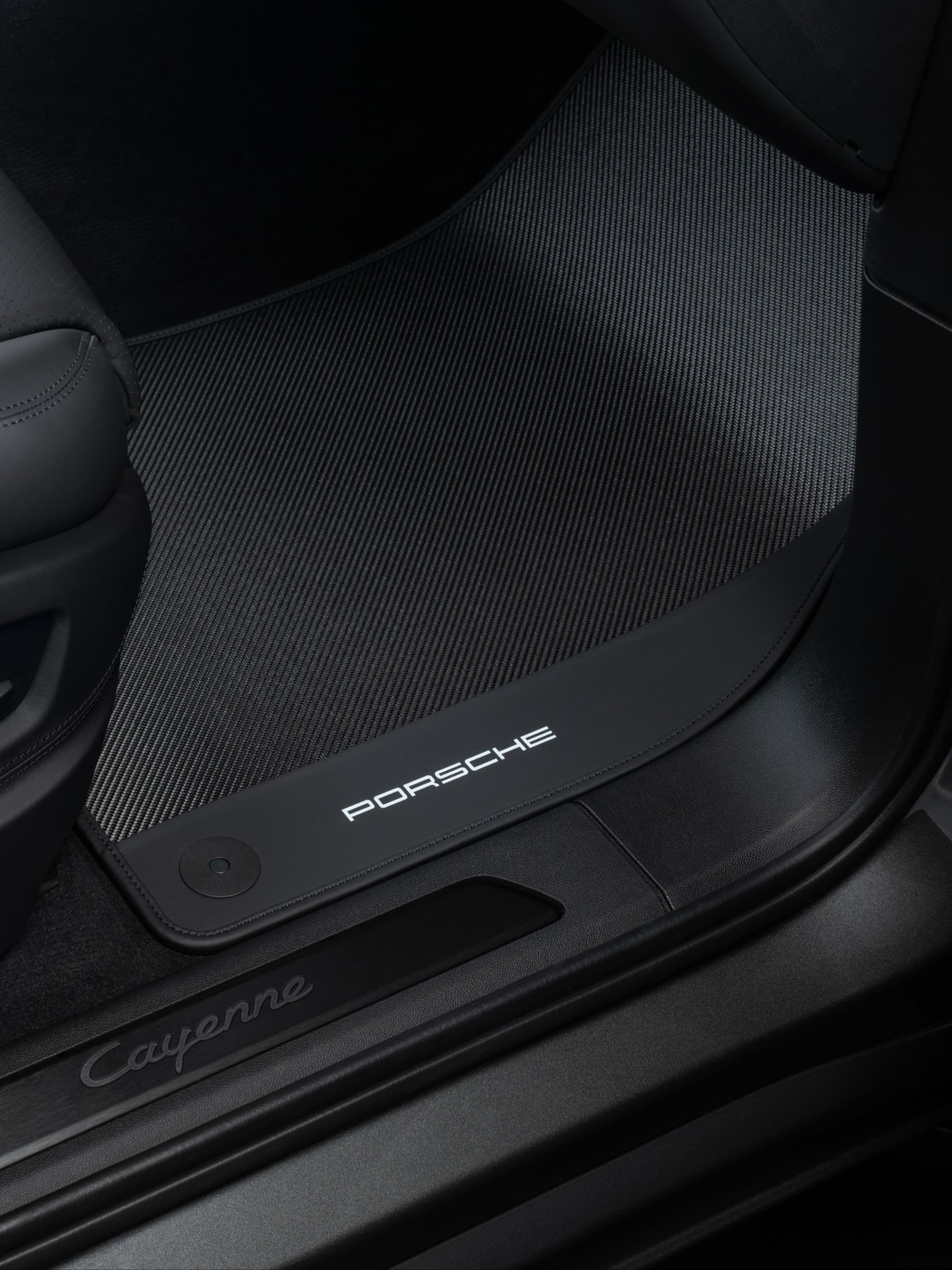 Schwarze Porsche Cayenne Fußmatte mit Logo, strukturierter Oberfläche und elegantem Design im Autoinnenraum.