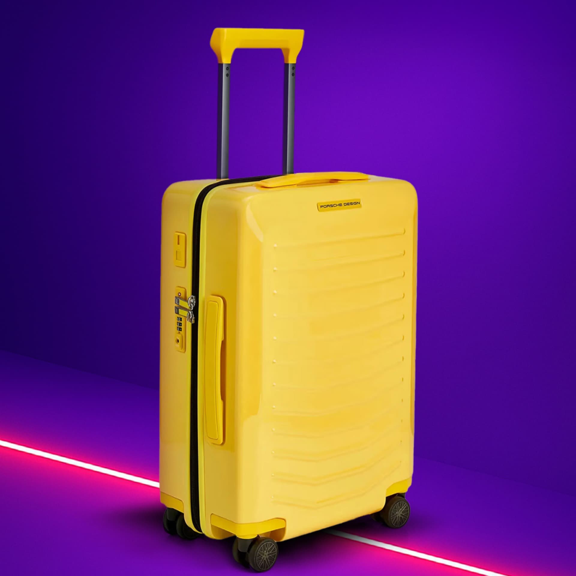 Gelber Koffer mit Teleskopgriff auf lila Hintergrund, mit Porsche Design Logo und vier Rädern.