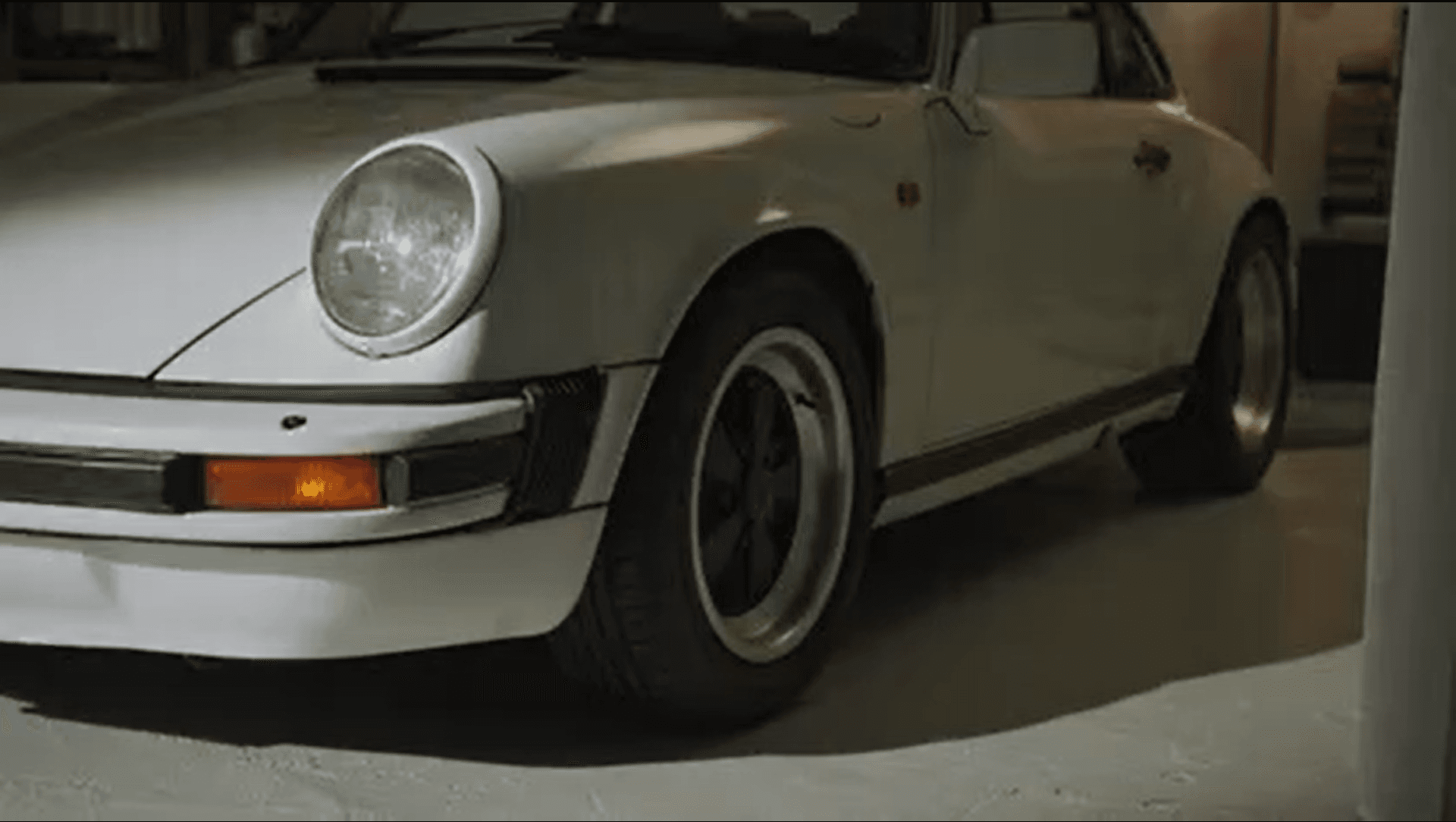 White historic Porsche car in a garage