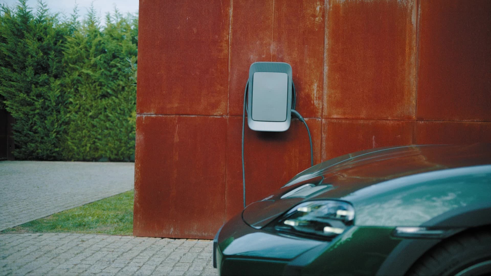 Porsche wallbox on a red wall in the focus