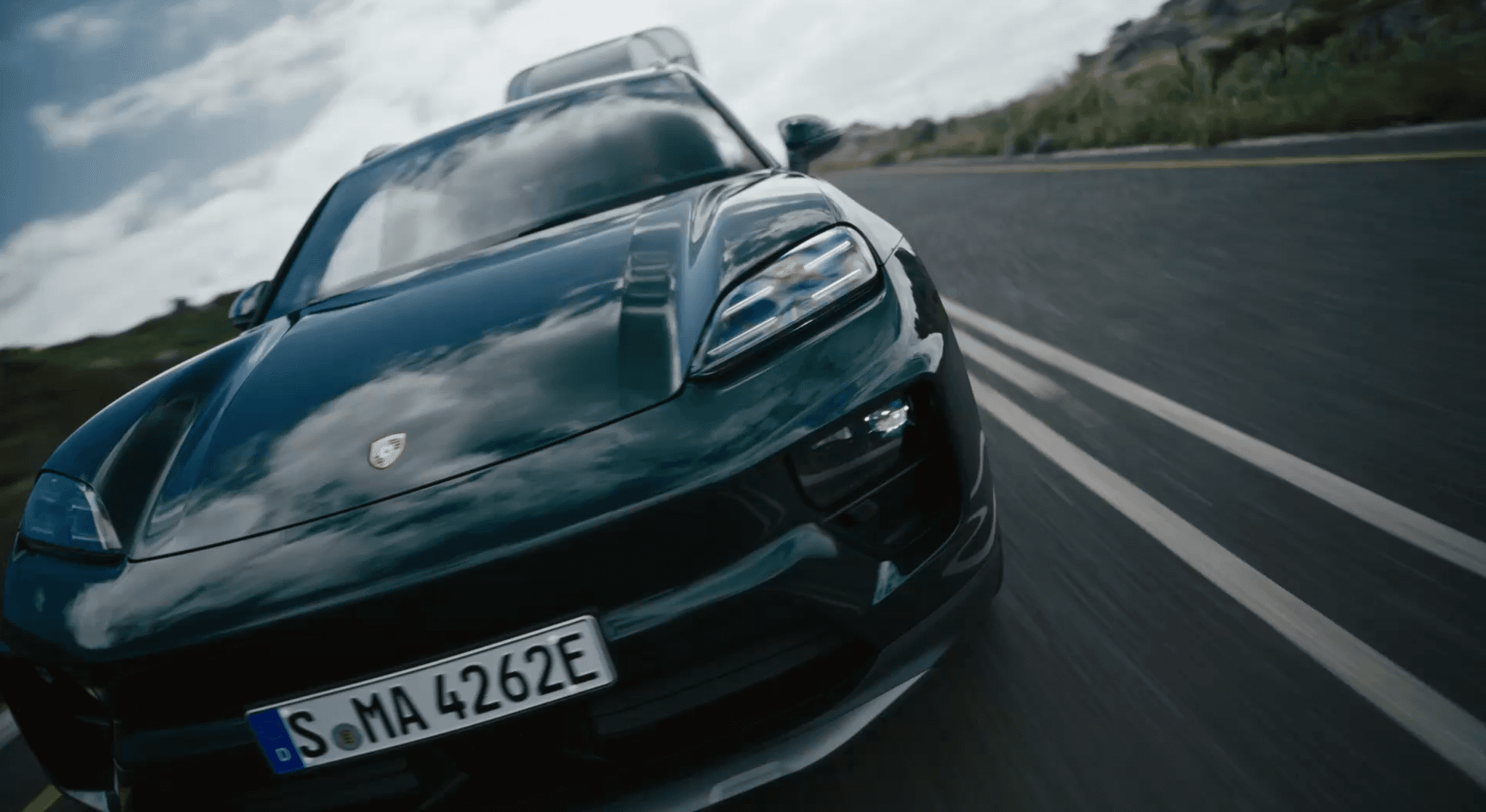 You can see an oakgreen Porsche Macan on a road