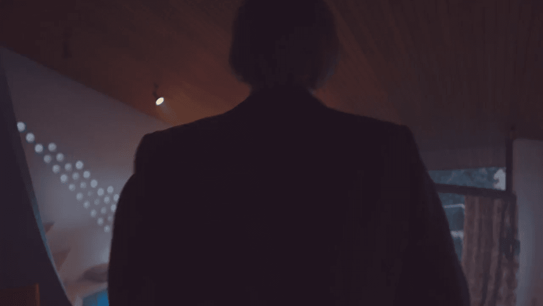 You can see a man walking through a house