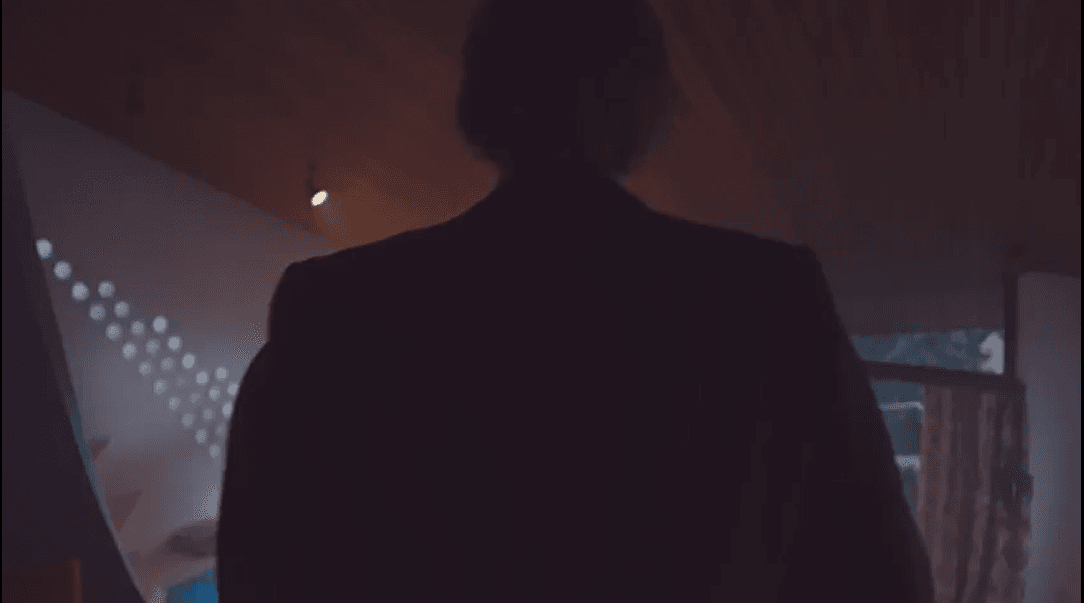 You can see a man walking through a house