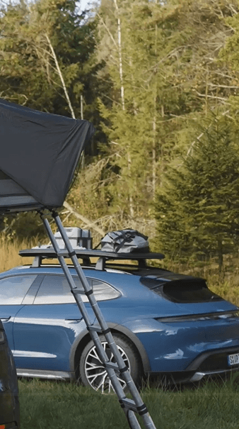 two Porsche cars next to each other in the forest with Porsche roof tent