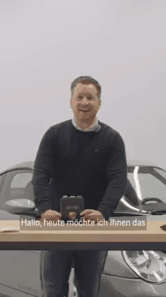 Mann steht an einem Tisch und erklärt das daraufliegende Produkt